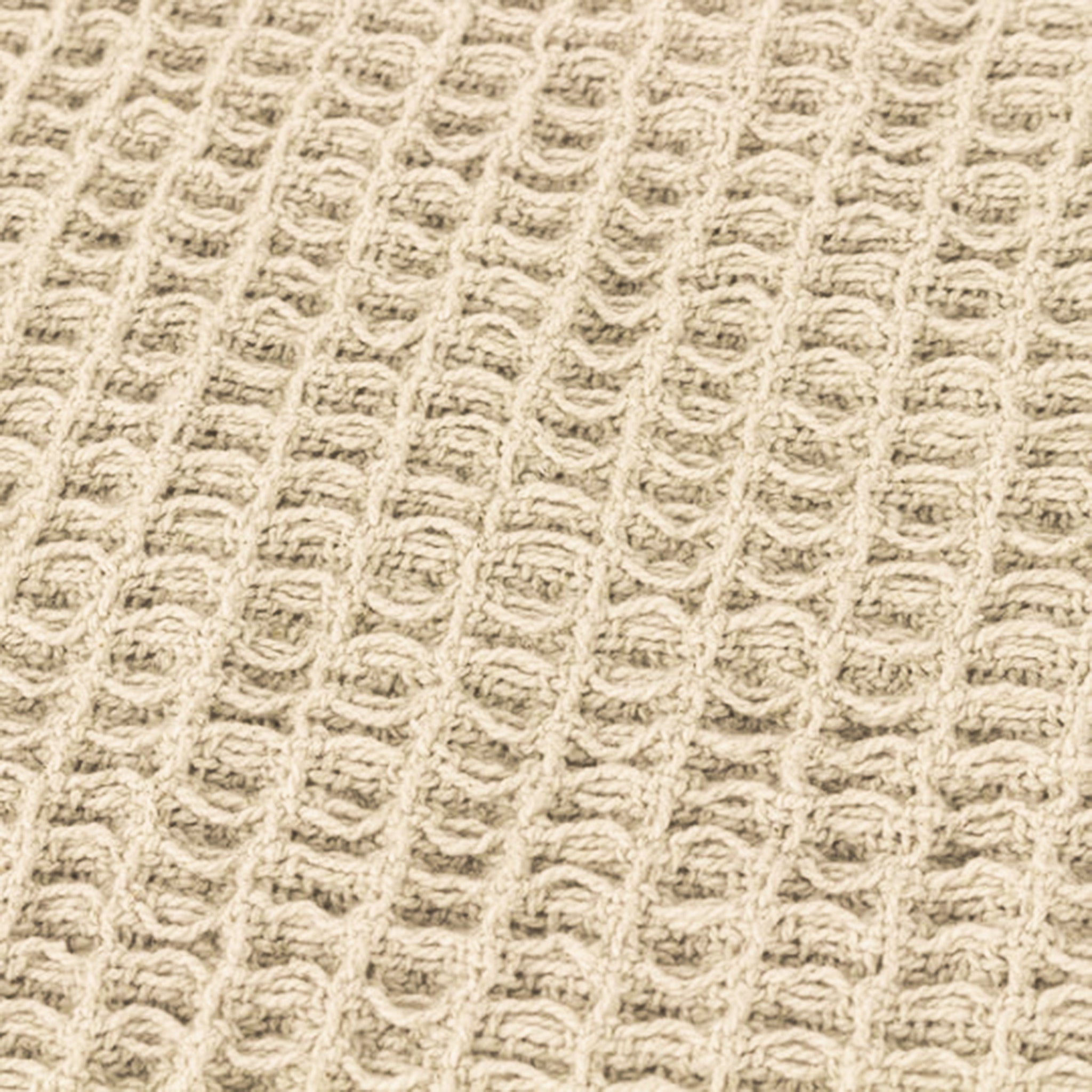 Detailed close-up of the Léna Oversized Cotton Throw highlighting its stone-toned waffle weave texture, raised woven pattern and tactile natural cotton finish.