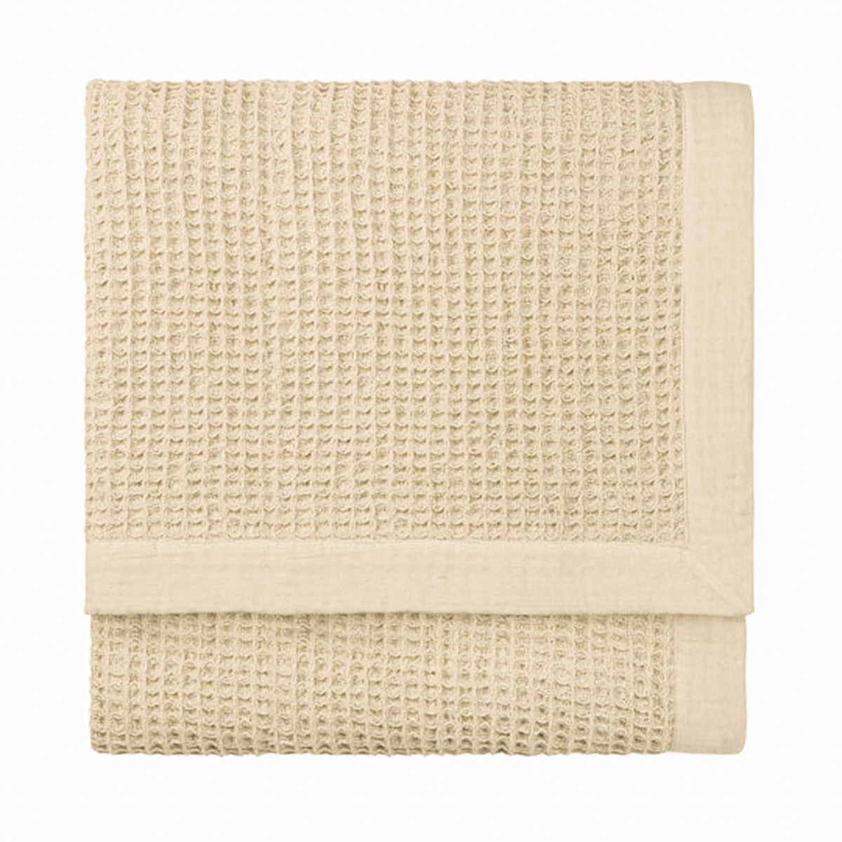 Folded Léna oversized cotton throw in stone and natural, featuring a tactile waffle weave texture with a smooth contrasting border for neutral bedroom and living room styling.