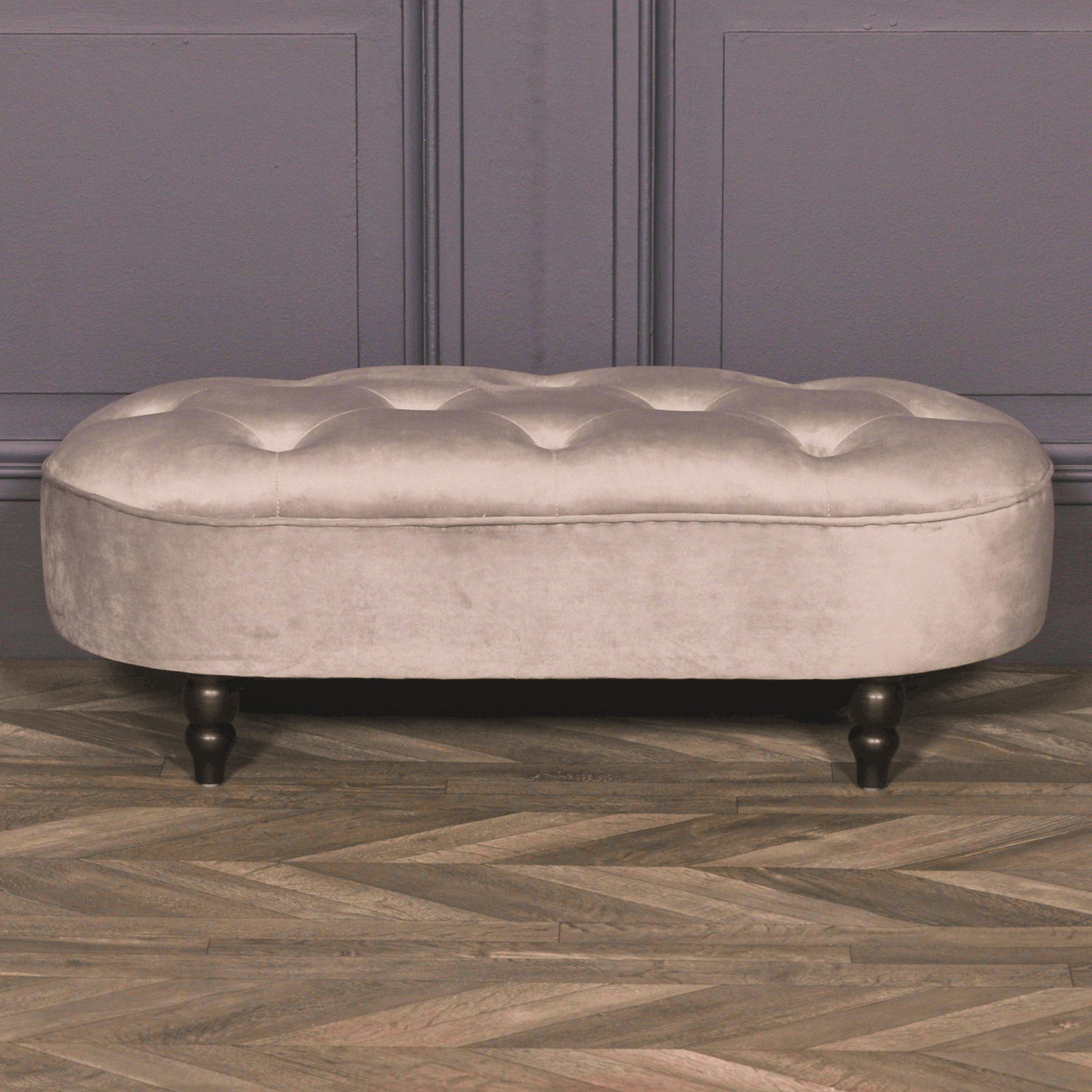Lucien Grey Velvet Upholstered Bedroom Bench with Black Legs displayed in an elegant interior, featuring luxurious grey velvet upholstery, a button tufted seat and timeless end of bed bench styling.