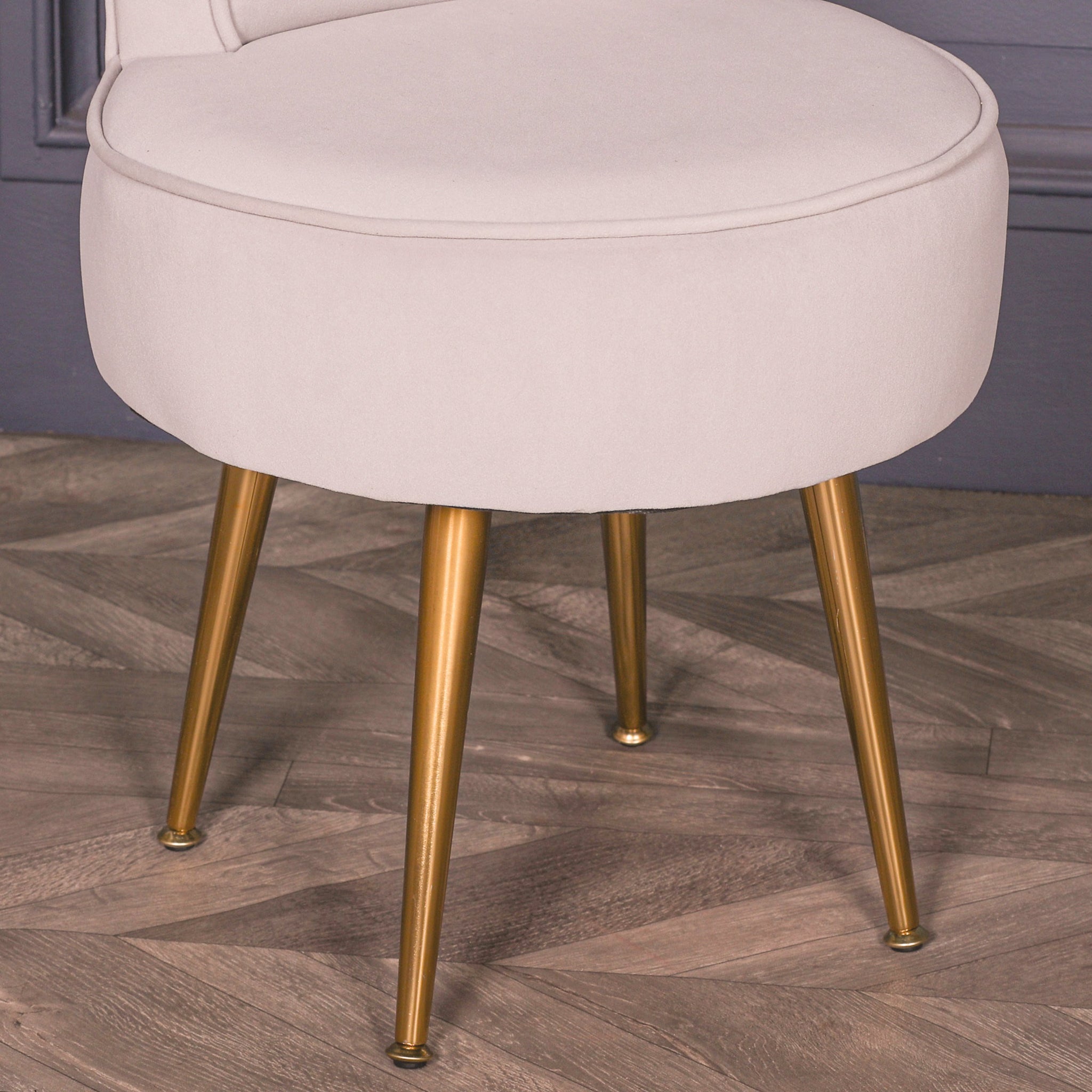 Close-up of the Lucien Light Grey Velvet Accent Bedroom Chair with Gold-Plated Legs highlighting the plush light grey velvet seat, premium upholstery, tailored piping and elegant tapered gold-plated legs.