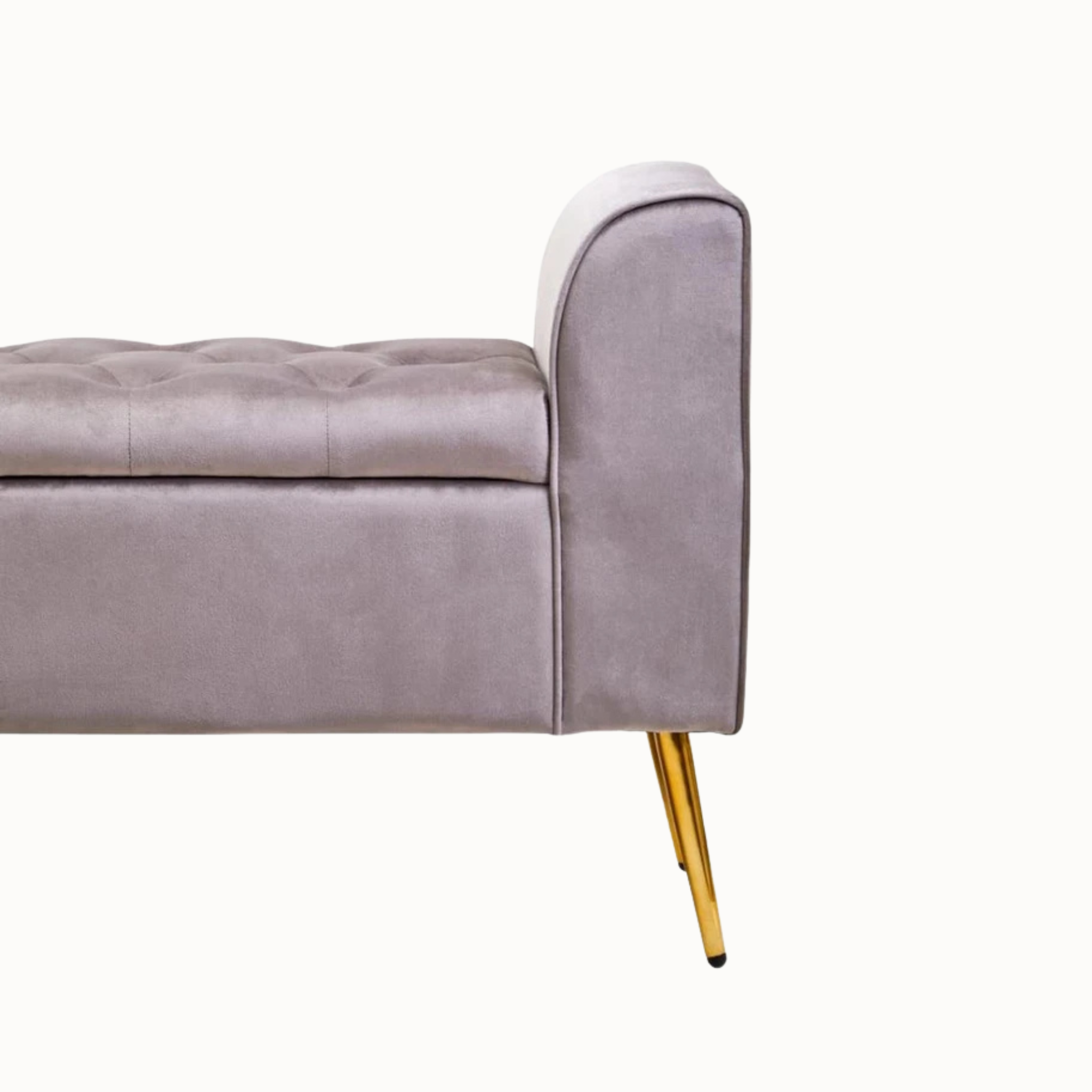 Side detail of Lucien mink velvet storage bench with tufted seat and gold iron leg on a plain white background.