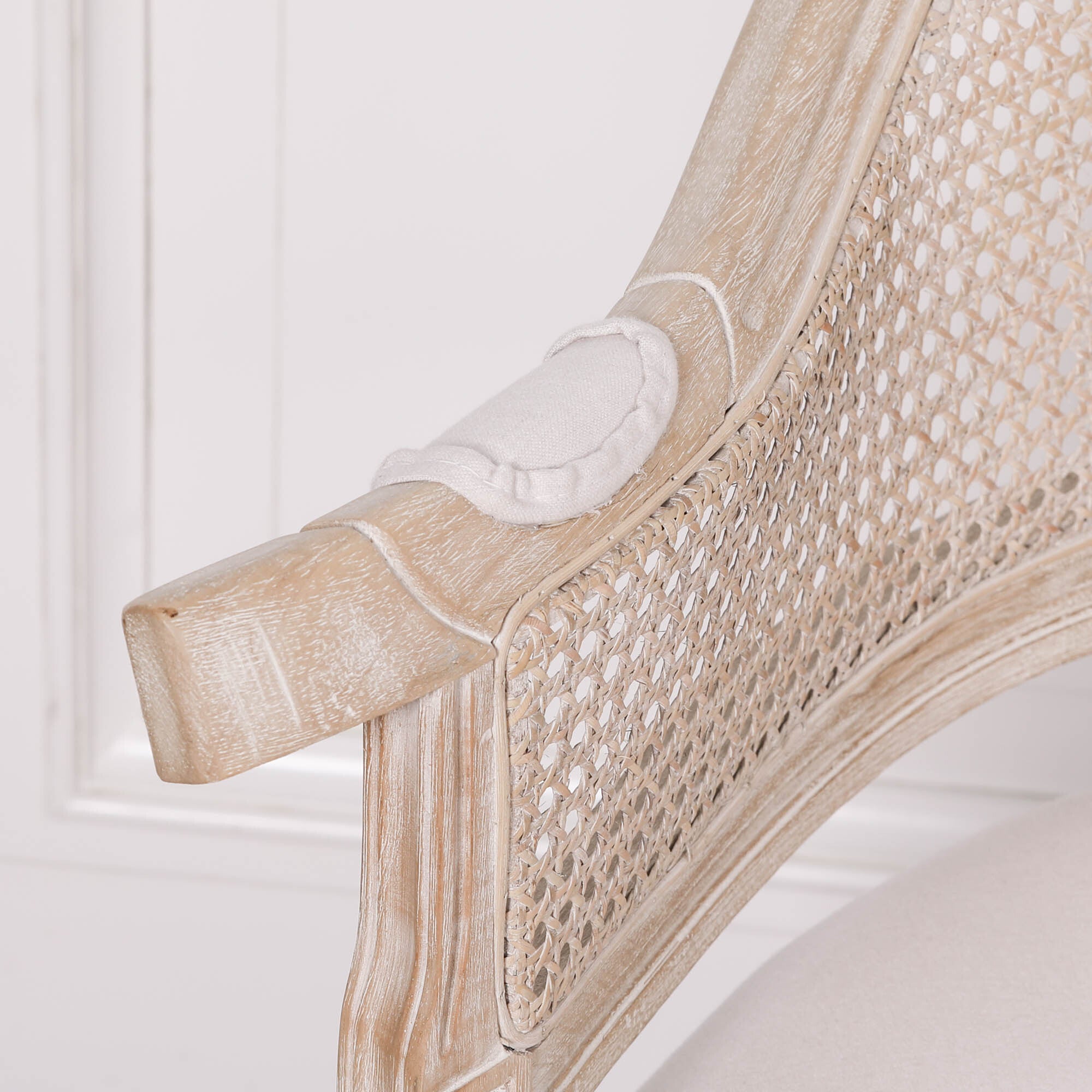Close-up of the Lucienne Louis corner chair showcasing the hand-woven cane backrest, carved washed wood frame and refined French Louis craftsmanship.