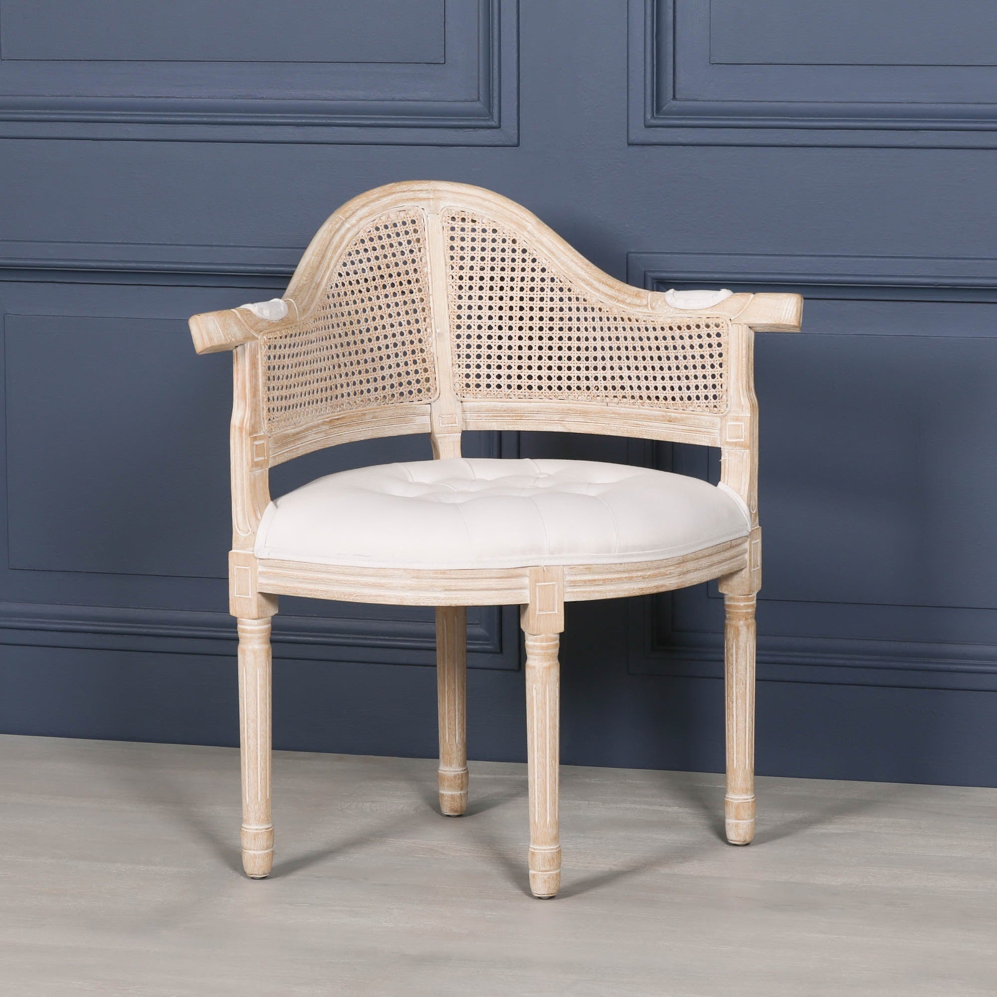 Front angled view of the Lucienne Louis corner chair featuring natural linen upholstery, woven cane backrest and a distressed washed wood frame.