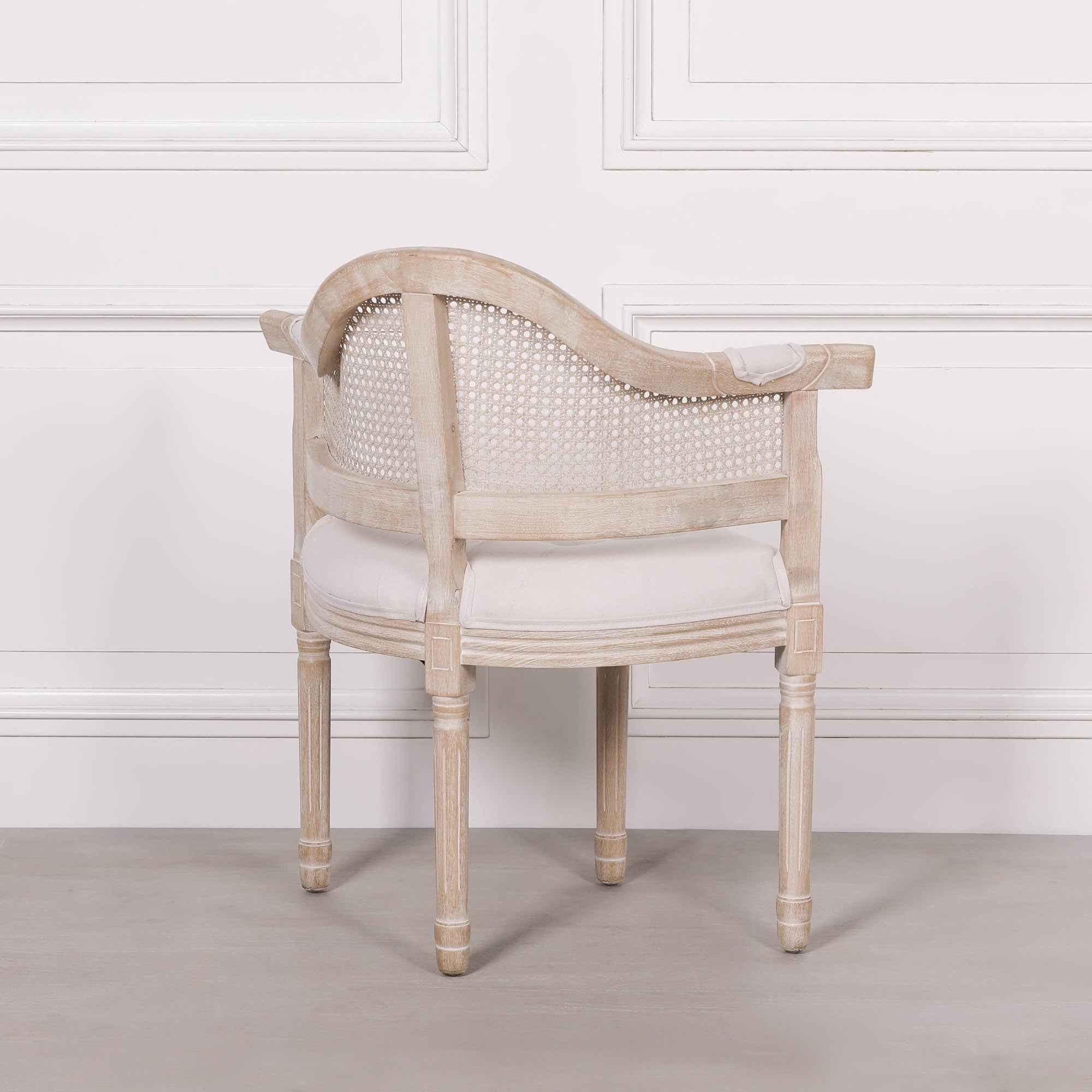 Rear view of the Lucienne Louis corner chair highlighting the woven cane back, curved silhouette and beautifully distressed washed wood frame.