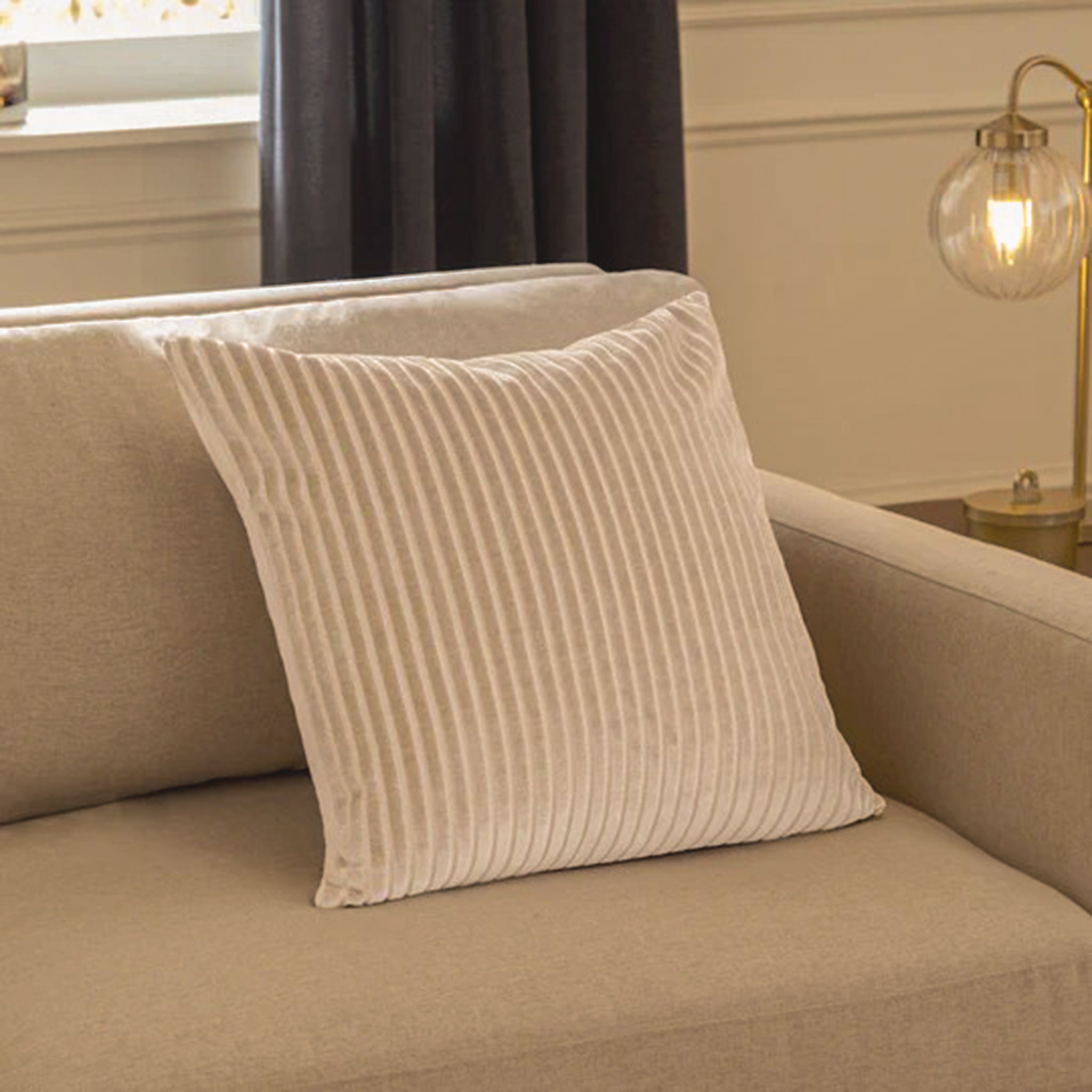 Maëva Cut Velvet Striped Cushion in Oyster Cream styled on a contemporary sofa, highlighting the plush cut velvet fabric, textured striped design and sophisticated neutral finish for elegant home styling.
