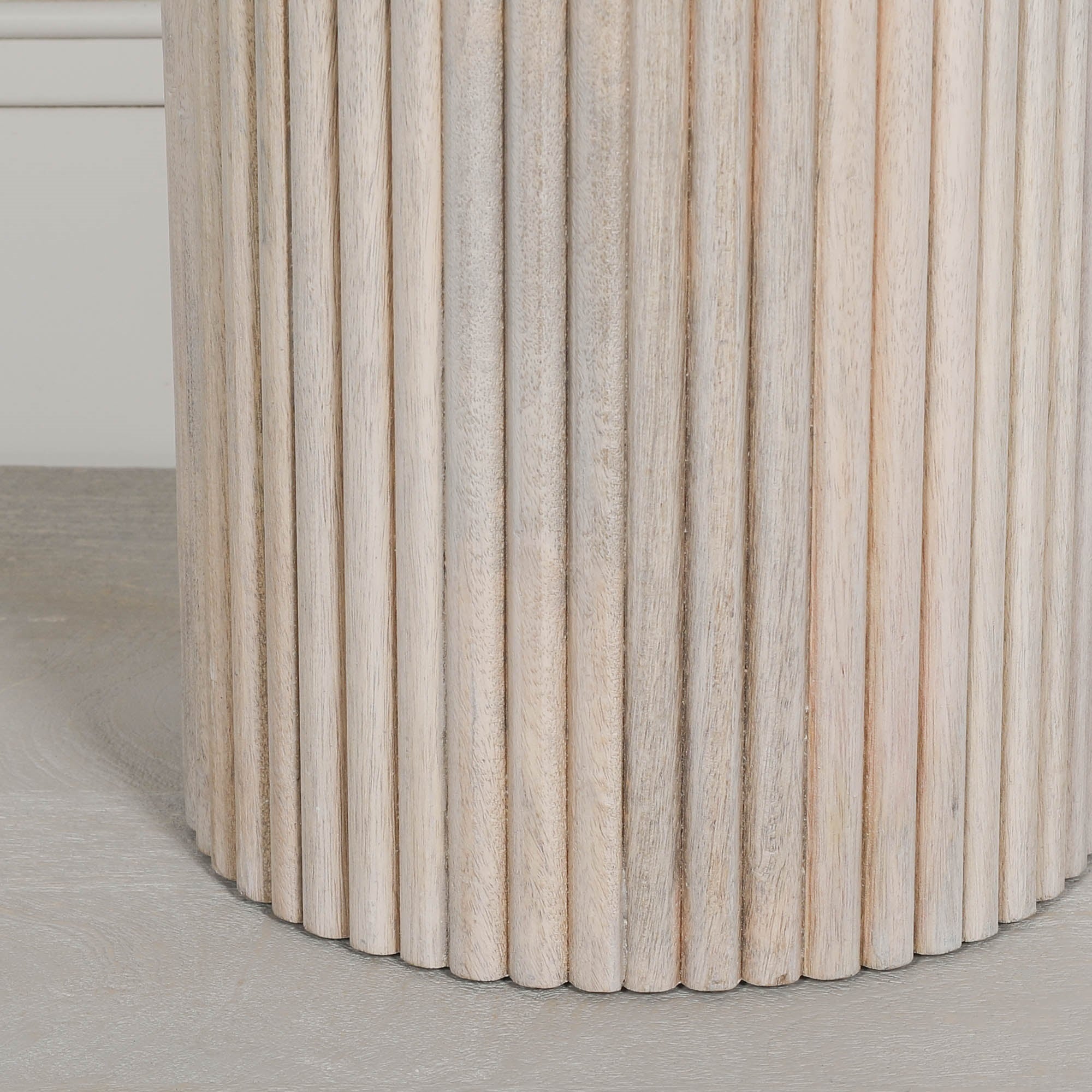 Detailed close-up of the Margaux ribbed round side table highlighting the handcrafted fluted mango wood pedestal base with a washed finish and natural timber texture for contemporary interiors.