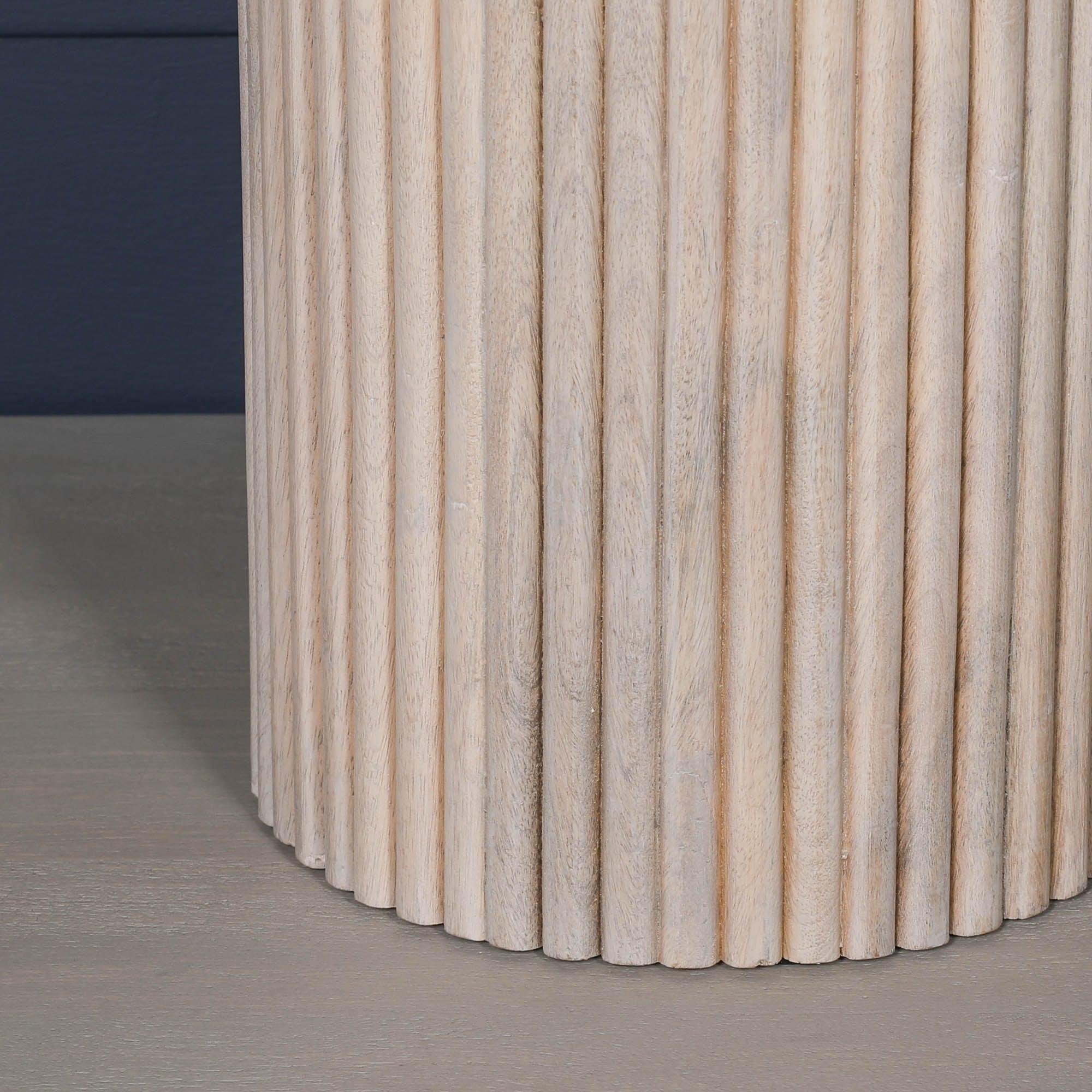 Close-up of the Margaux ribbed round side table pedestal base featuring vertical fluted detailing, solid washed mango wood construction and handcrafted natural timber finish.