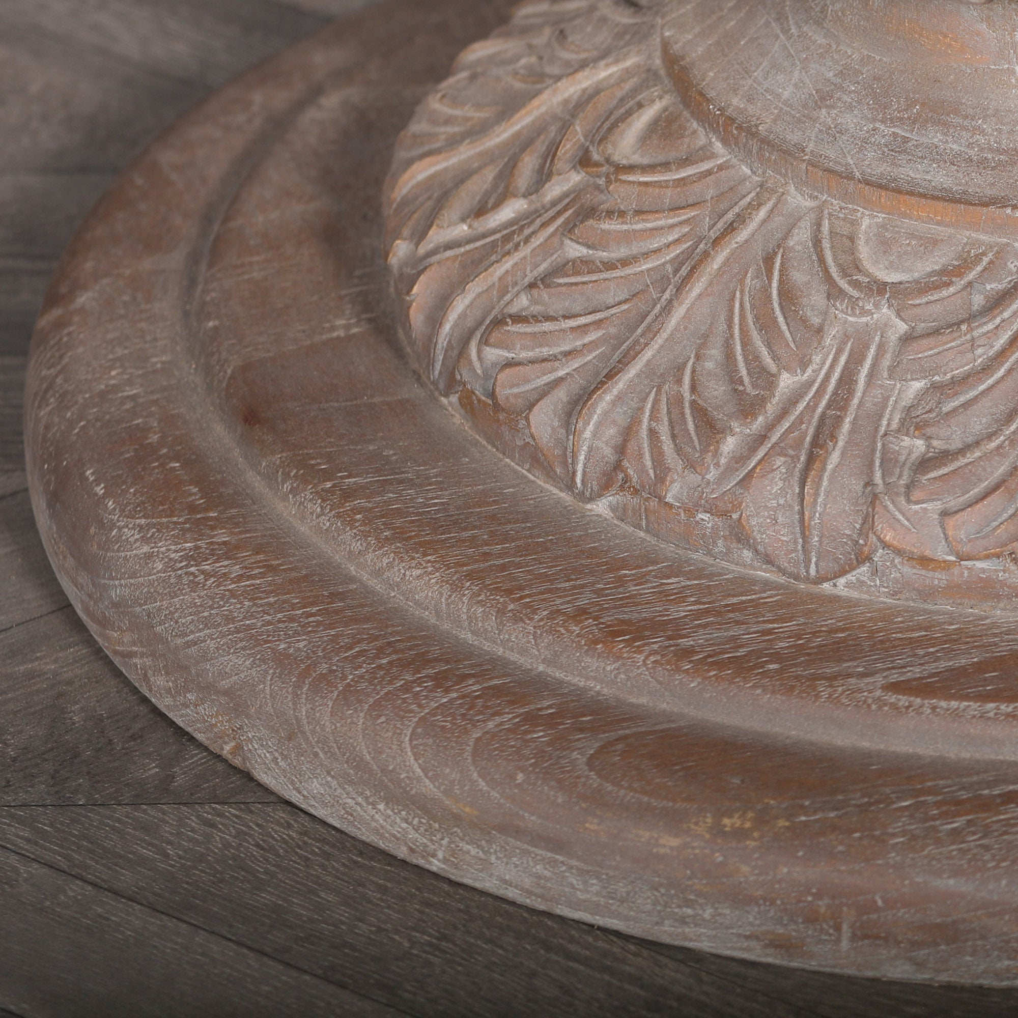 Close-up of the hand-carved acorn pedestal base on the Mathis reclaimed cedar wood round dining table.
