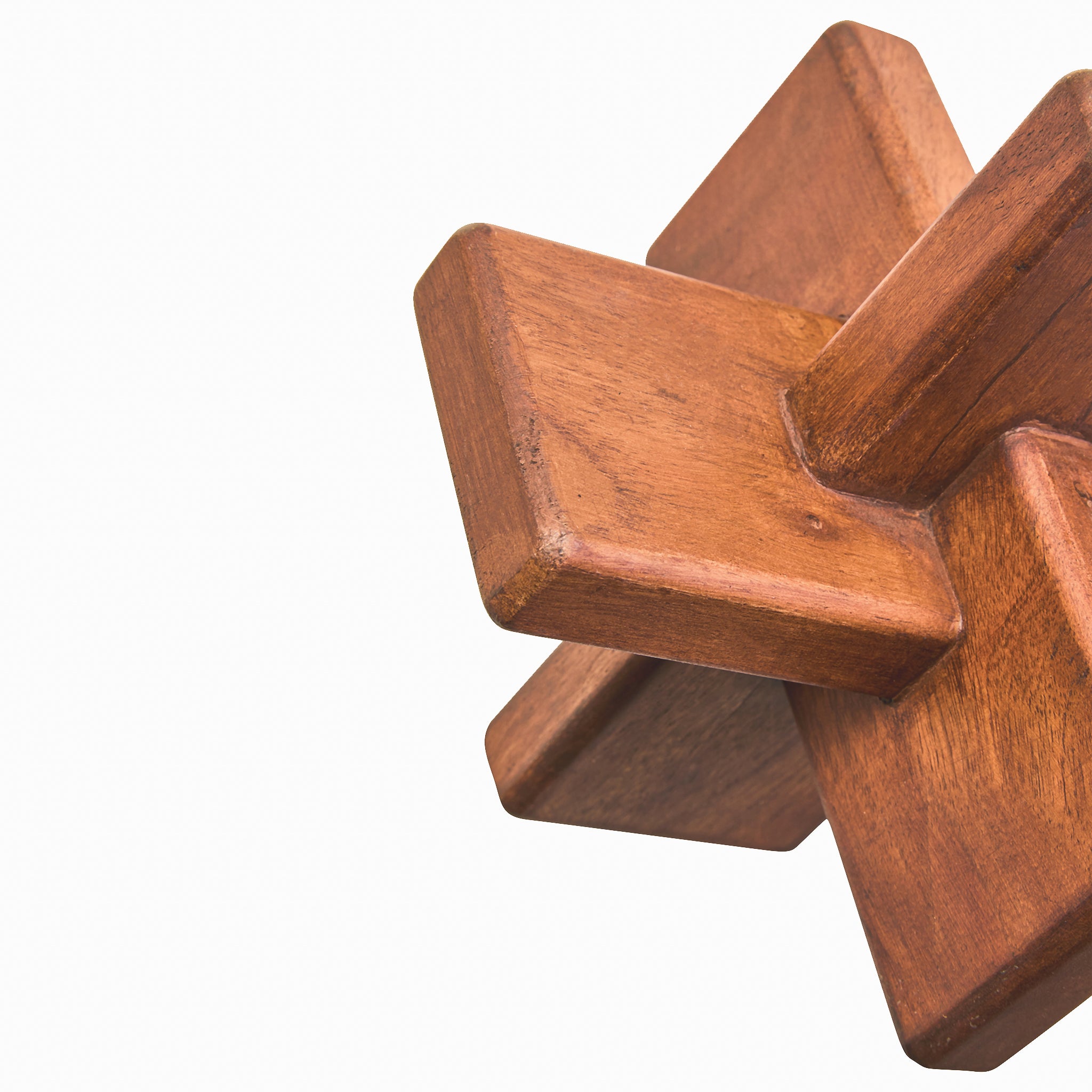Detailed angled view of the Noé hand-carved acacia wood sculpture showing its geometric interlocking design, brown finish and natural timber grain