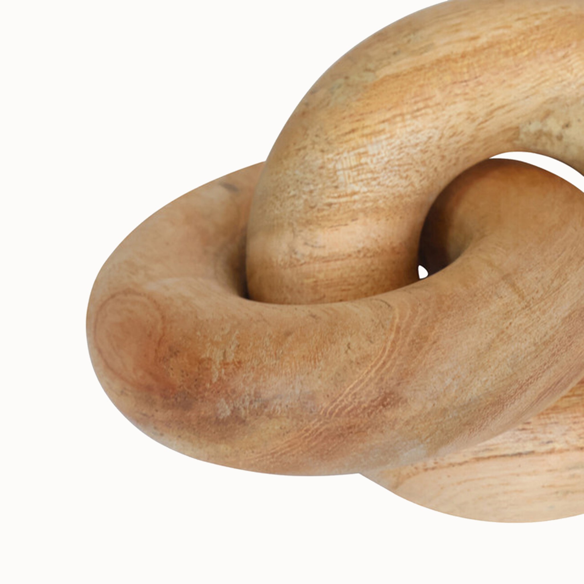 Close-up of the Noé handcrafted wooden knot sculpture highlighting the interlocking curved form, organic wood grain, natural tonal variations and smooth sculptural finish.