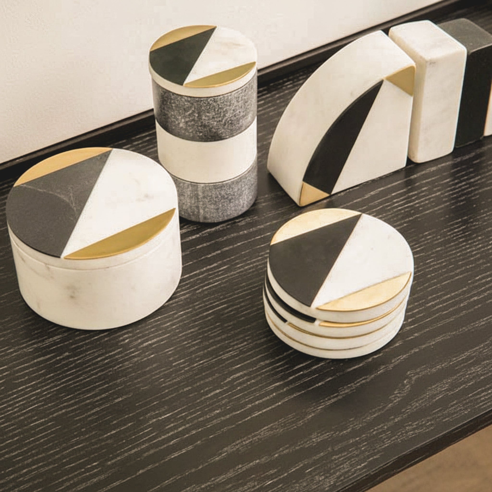Noé Rounded Trinket Box styled with coordinating black, white and gold marble decorative accessories on a dark wood surface, showcasing its geometric lid and elegant round form.