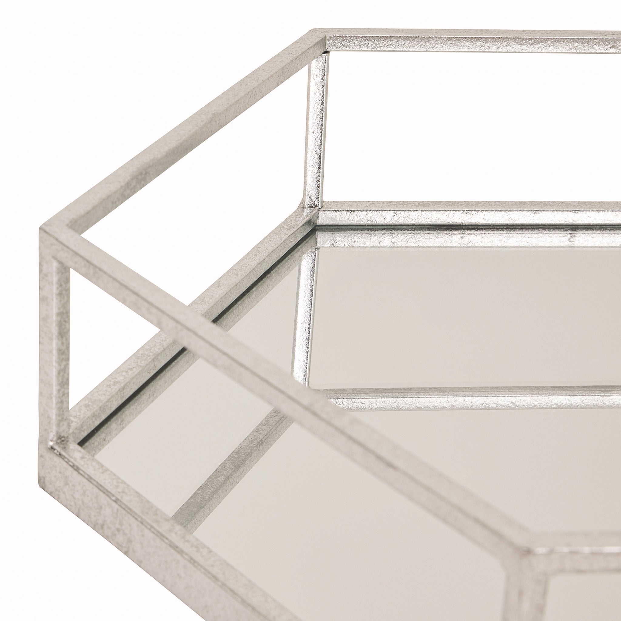 Close-up of the Noé silver metal and glass hexagon tray showcasing the mirrored glass base, geometric silver metal frame and refined handcrafted finish with clean contemporary lines.