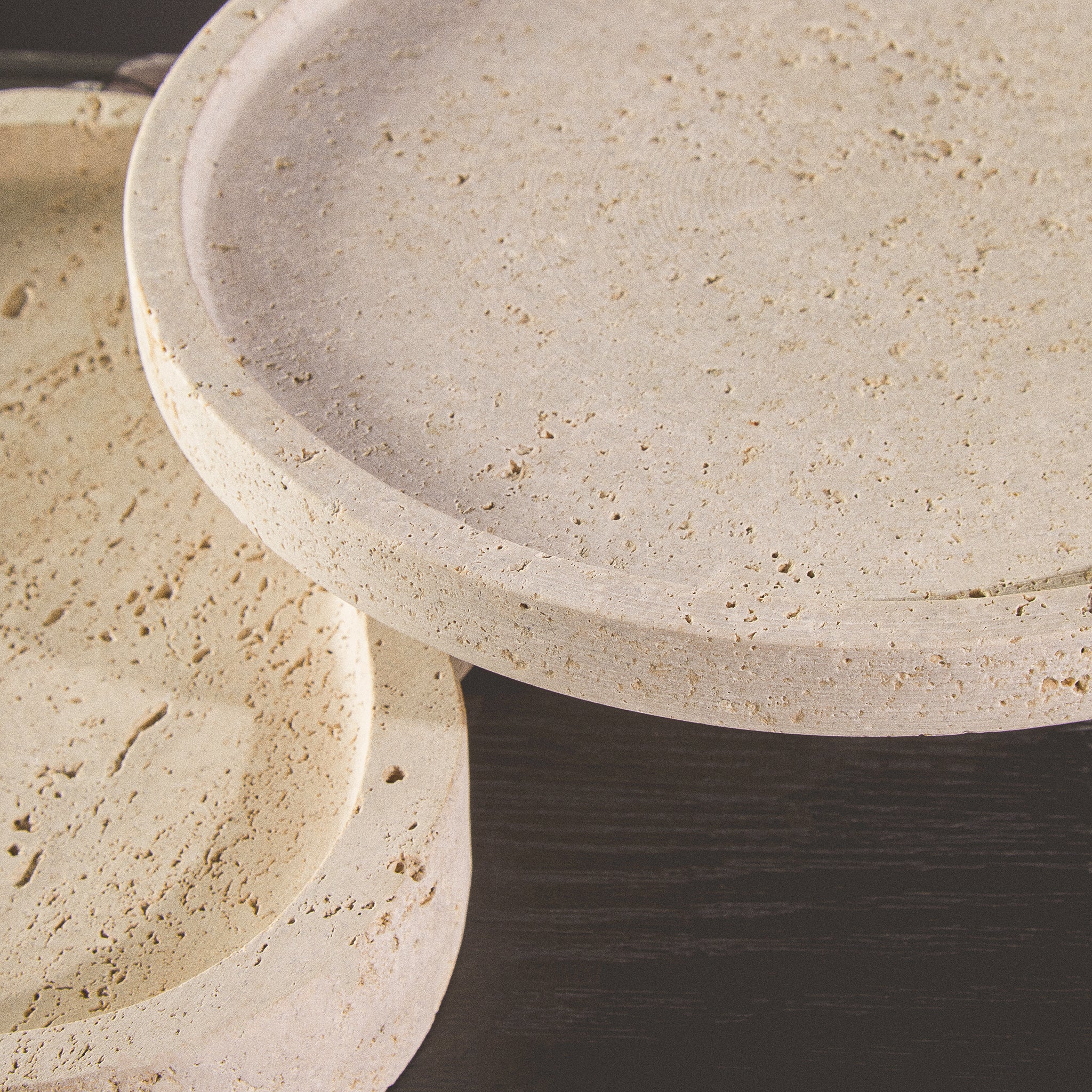 Close-up detail of the Noé Travertine Tray showing the naturally pitted stone surface, raised edge and unique tonal variations of the travertine.