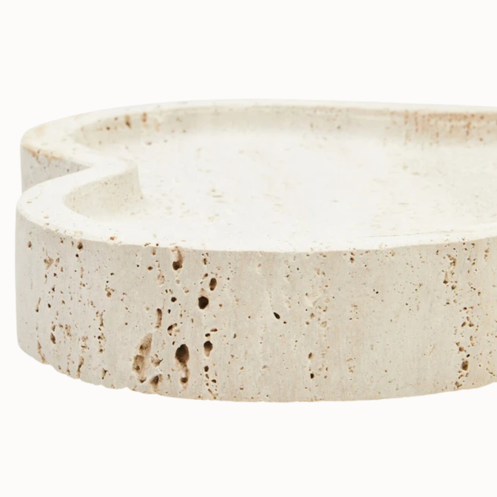 Close-up of Noé travertine tray with raised organic rim and porous beige stone texture on a white background.