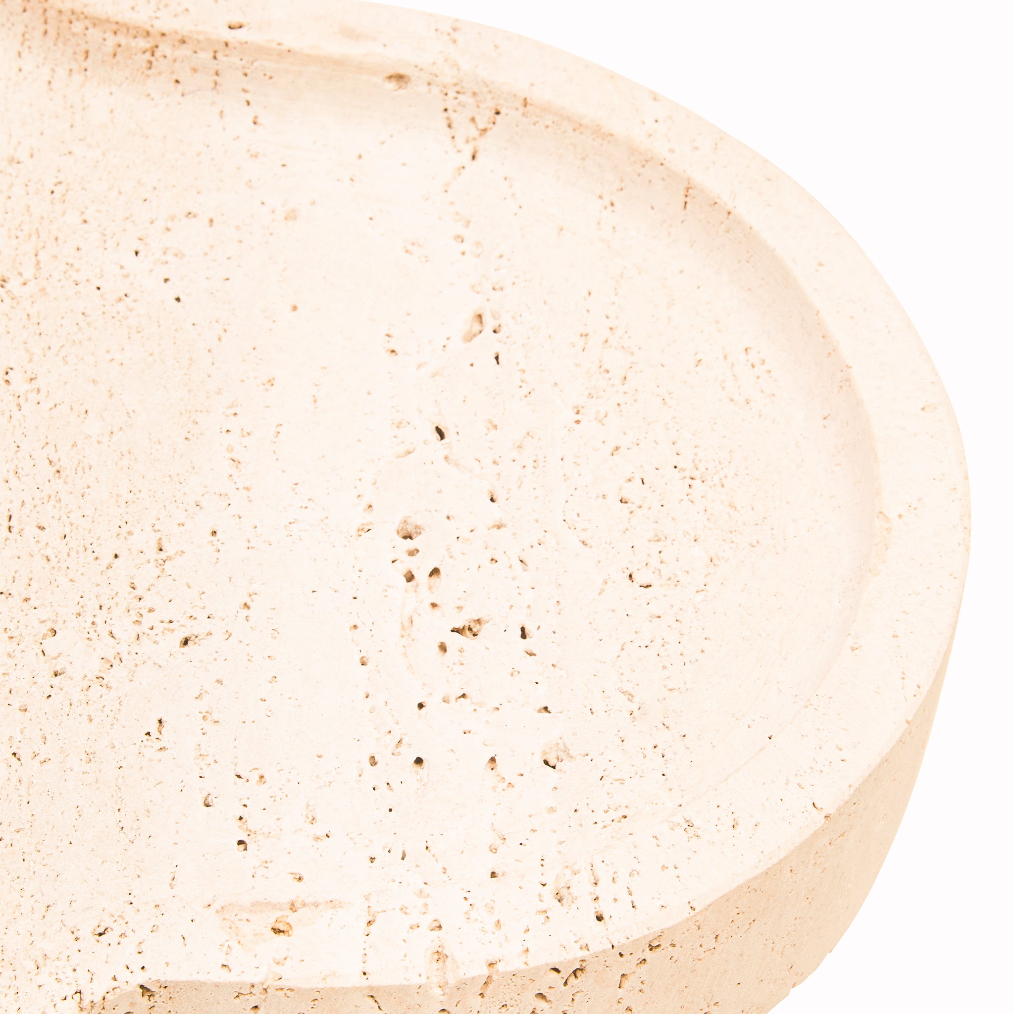 Close-up of the Noé Travertine Tray highlighting the recessed interior, curved raised rim and natural pores and markings across the travertine stone.
