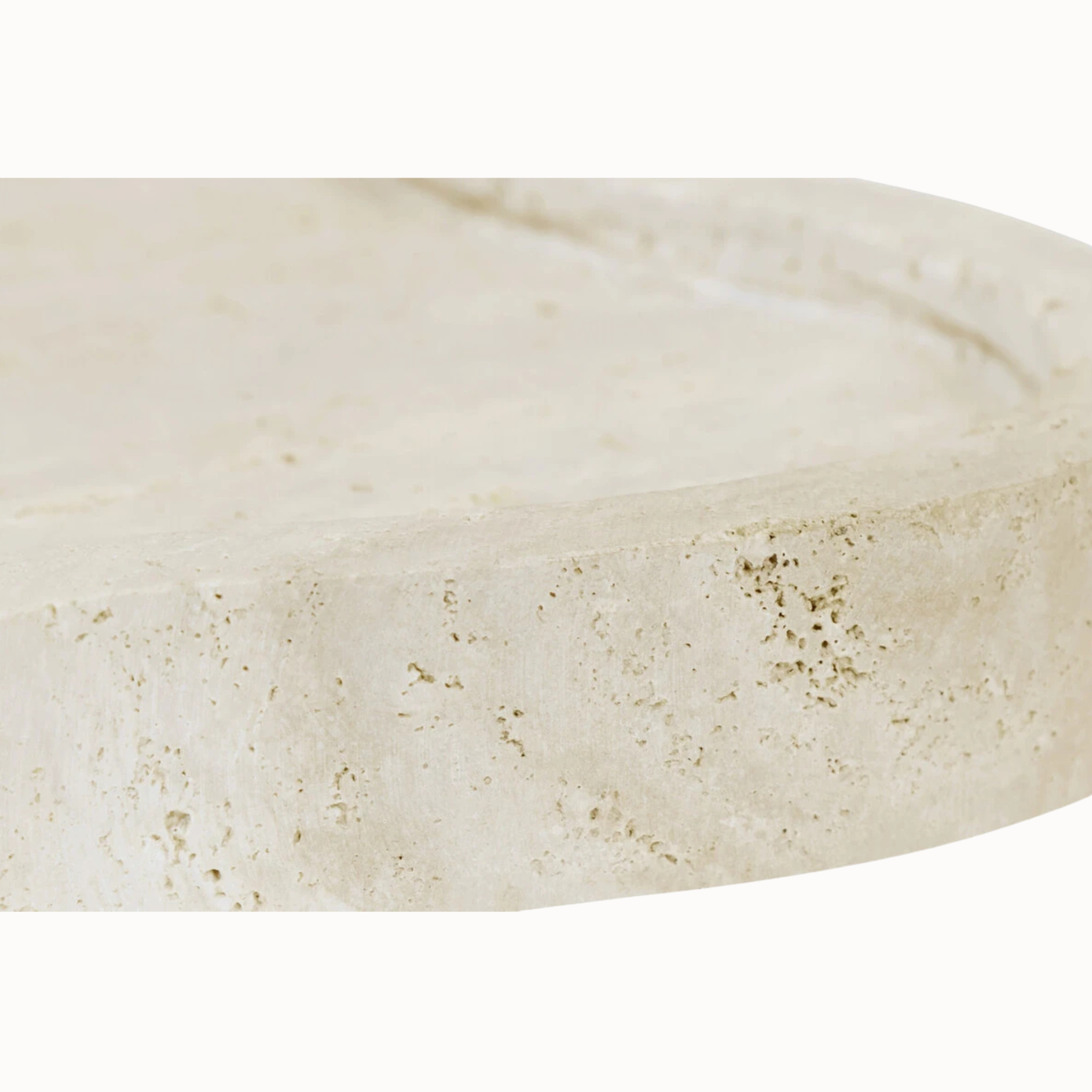 Close-up of Noé travertine tray edge showing natural pores, beige tonal variation and stone texture on white.
