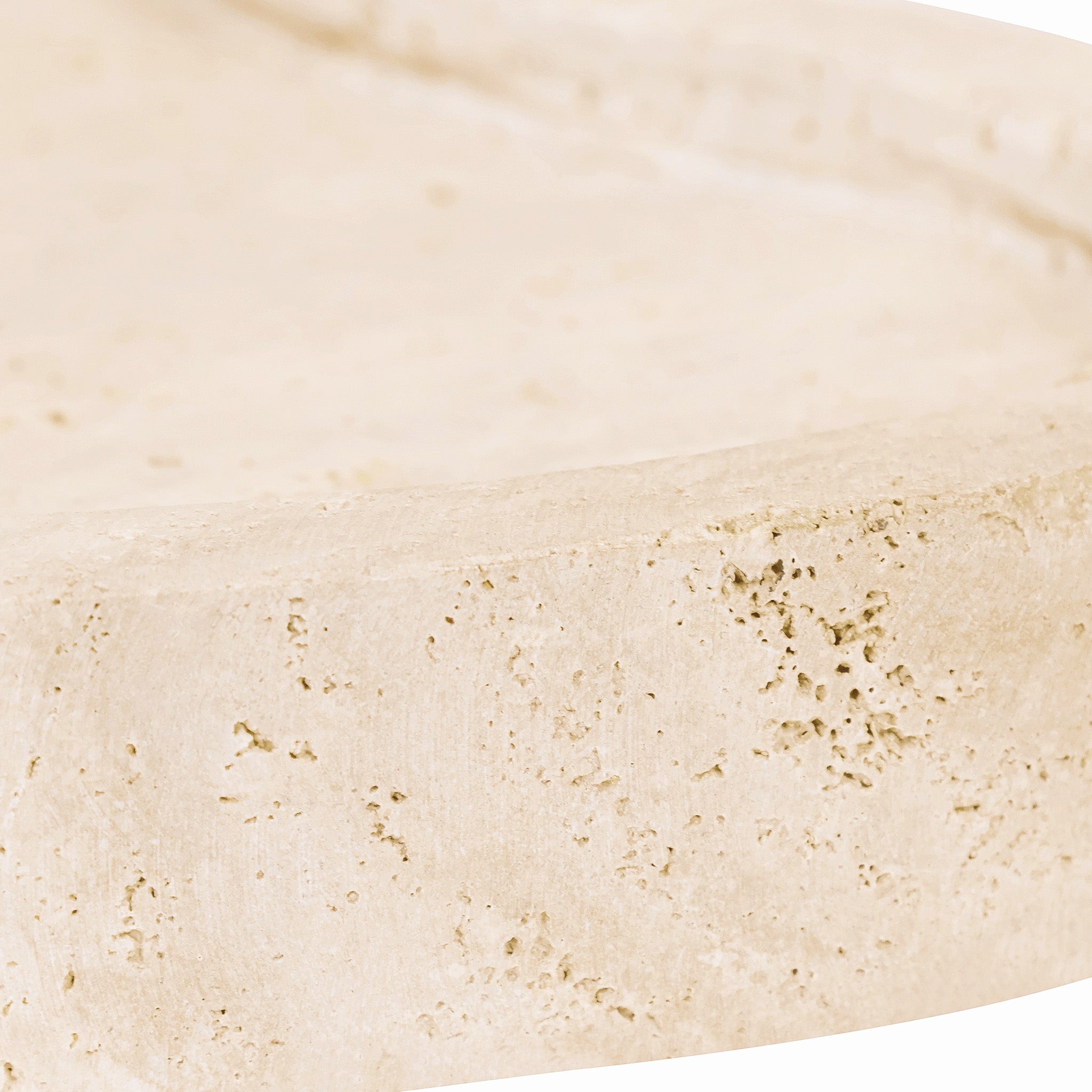 Close-up side detail of the Noé Travertine Tray highlighting its thick sculpted edge, shallow recessed top and naturally pitted travertine stone surface.