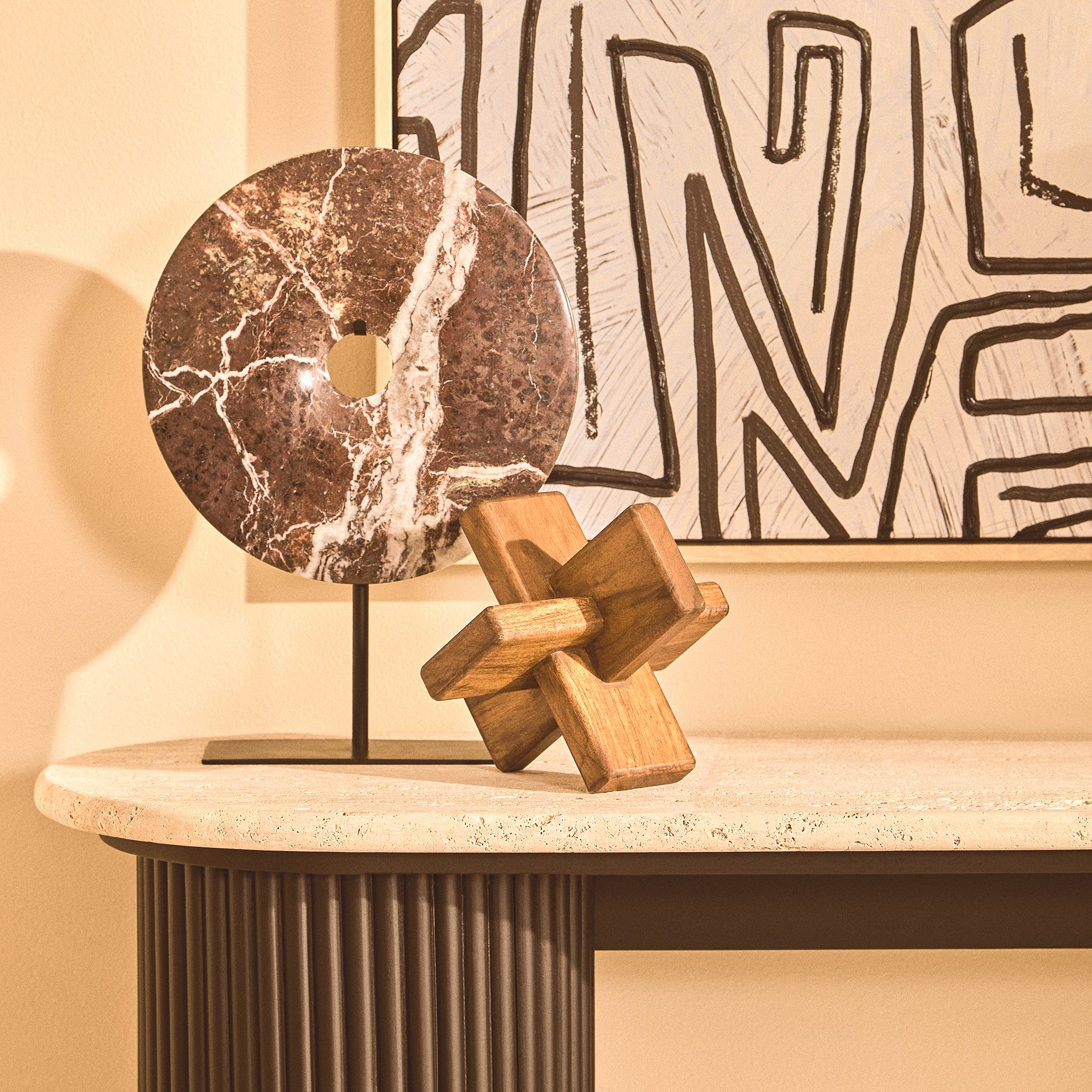 Noé hand-carved acacia wood decorative sculpture styled on a stone console table beside a circular marble ornament and abstract artwork