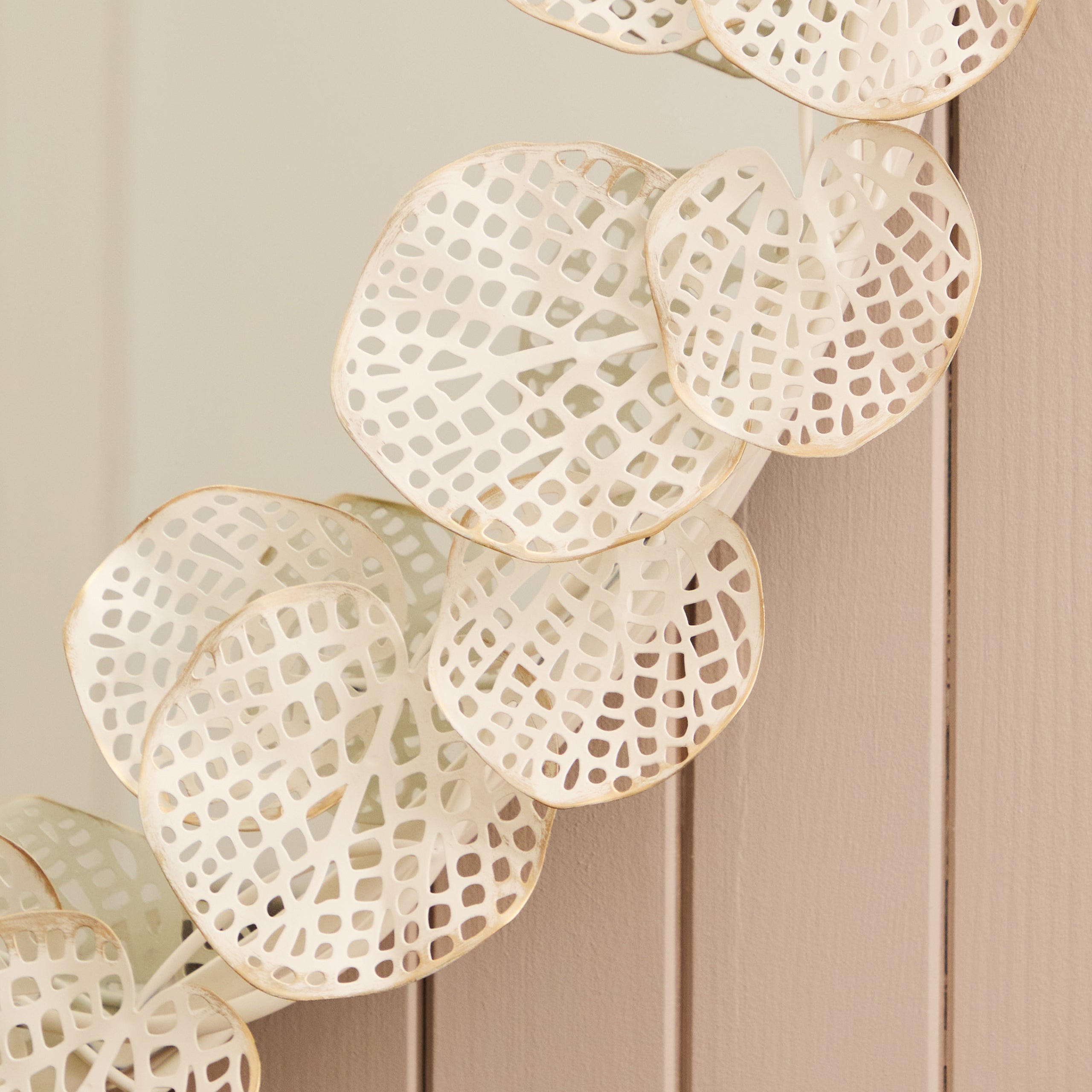 Close-up of the Odette 109cm Round Wall Mirror highlighting the intricate antique white and gold floral metal frame with delicate pierced leaf detailing and handcrafted decorative finish.