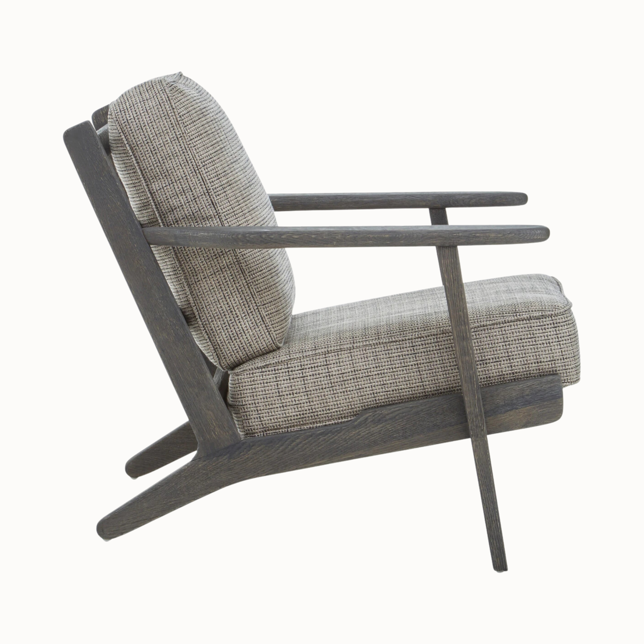 Side view of Rémi grey tweed armchair showing black American oak frame and cushions on a plain white background.