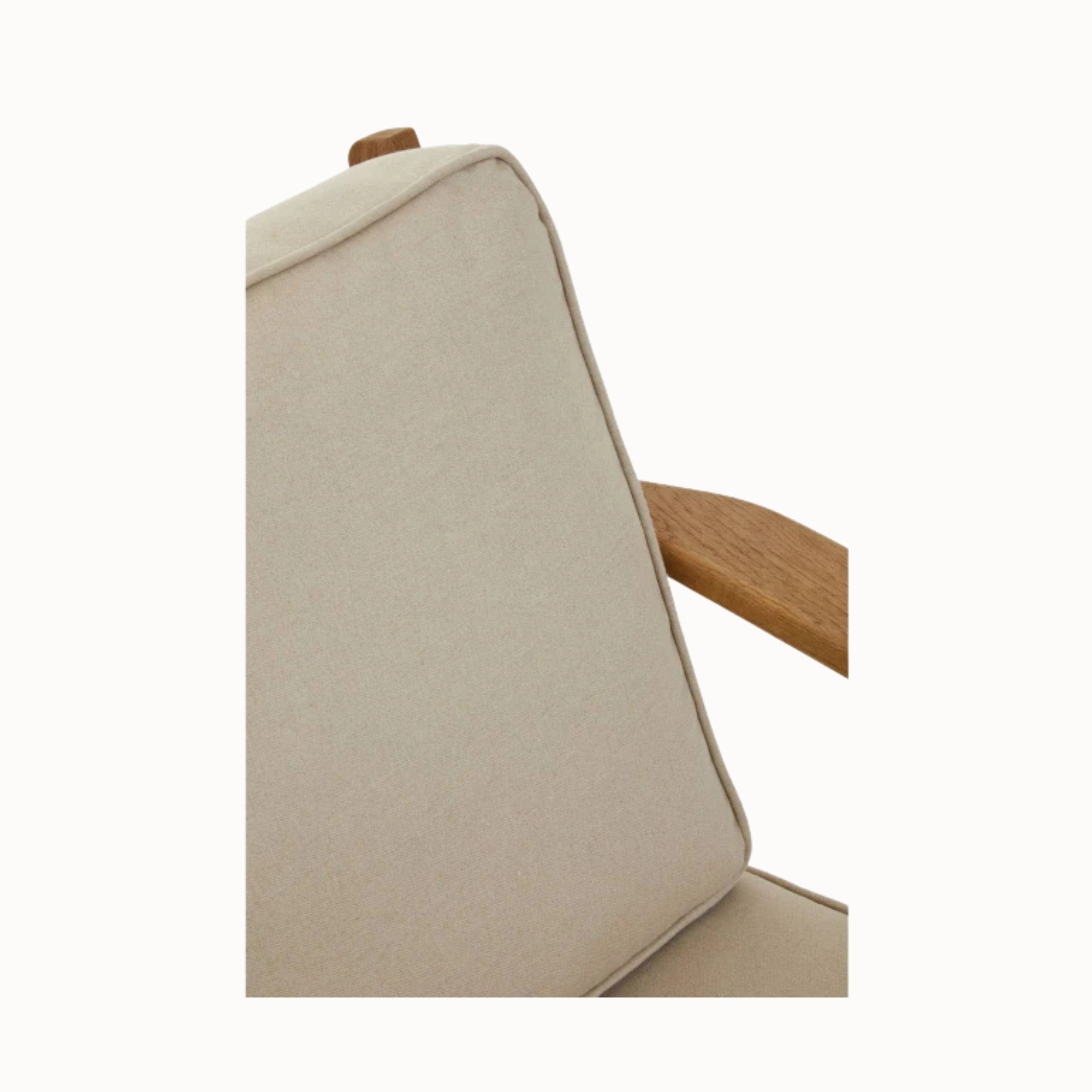 Close-up of Rémi natural linen armchair cushion and dark American oak armrest on a plain white background.