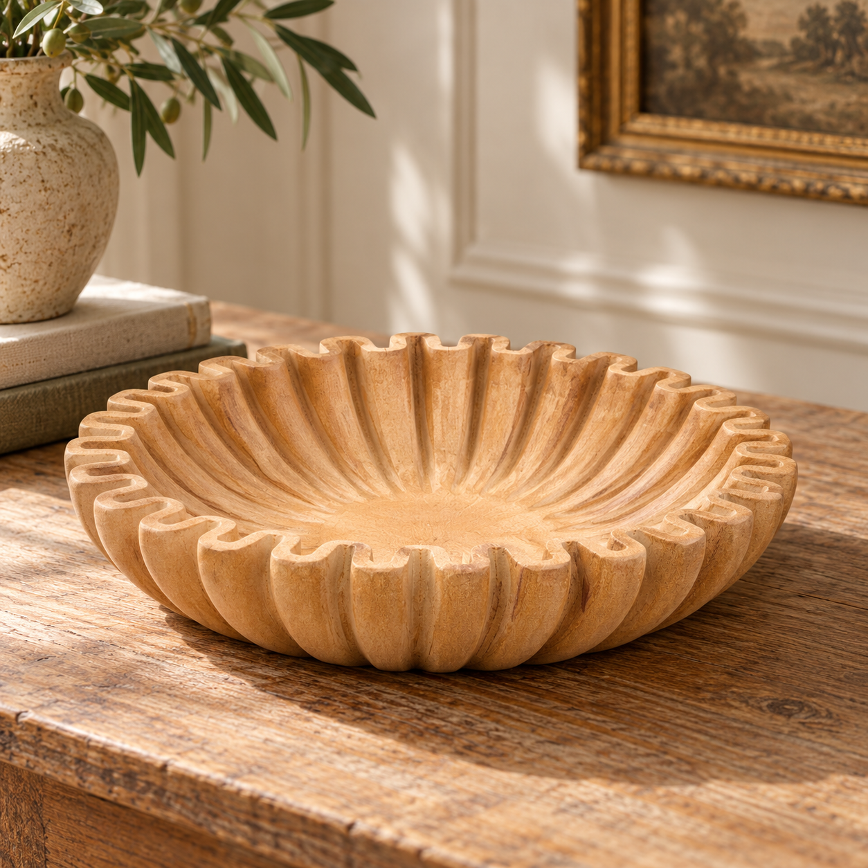 Renaud 25cm ochre marble fluted decorative bowl on a rustic wood table in a sunlit room with artwork and greenery.