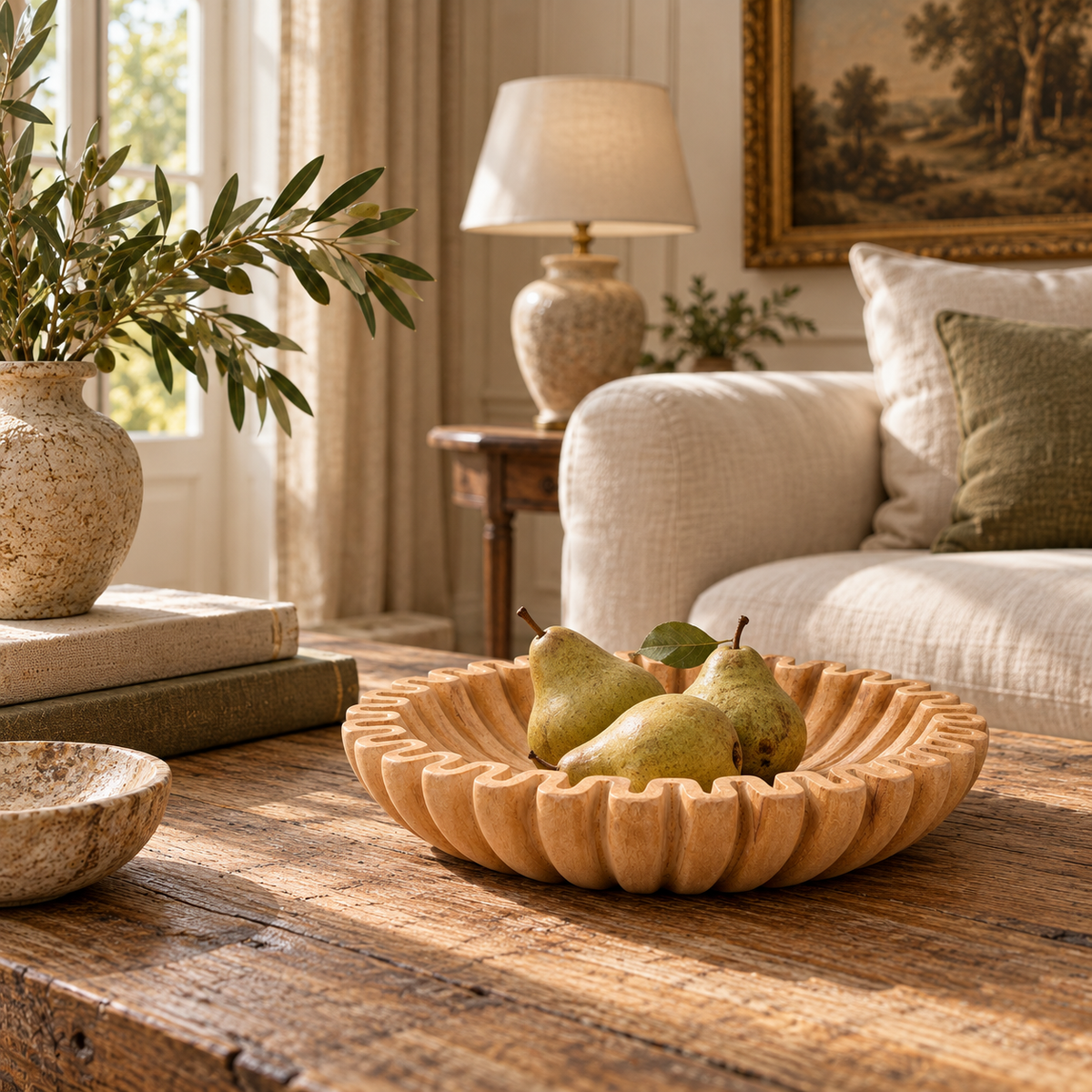 Renaud ochre marble fluted decorative bowl filled with pears on a rustic coffee table in a warm living room with sofa.