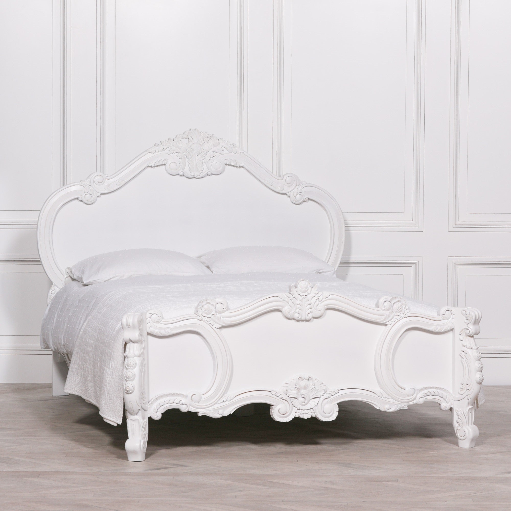 Front view of the Rosalie French Rococo double bed frame featuring elegant hand-carved floral scrollwork, rose carvings and cherub detailing in a bright white panelled bedroom.