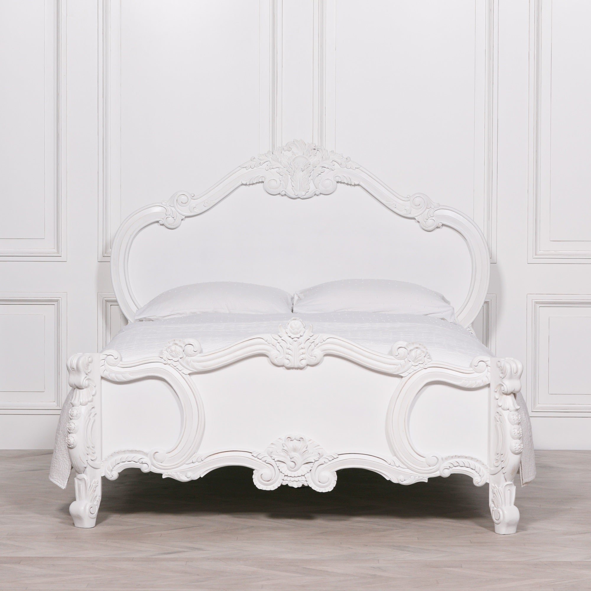 Rosalie French Rococo 4ft6 double bed frame with hand-carved rose and cherub detailing in a light painted white finish styled against classic white panelled walls.