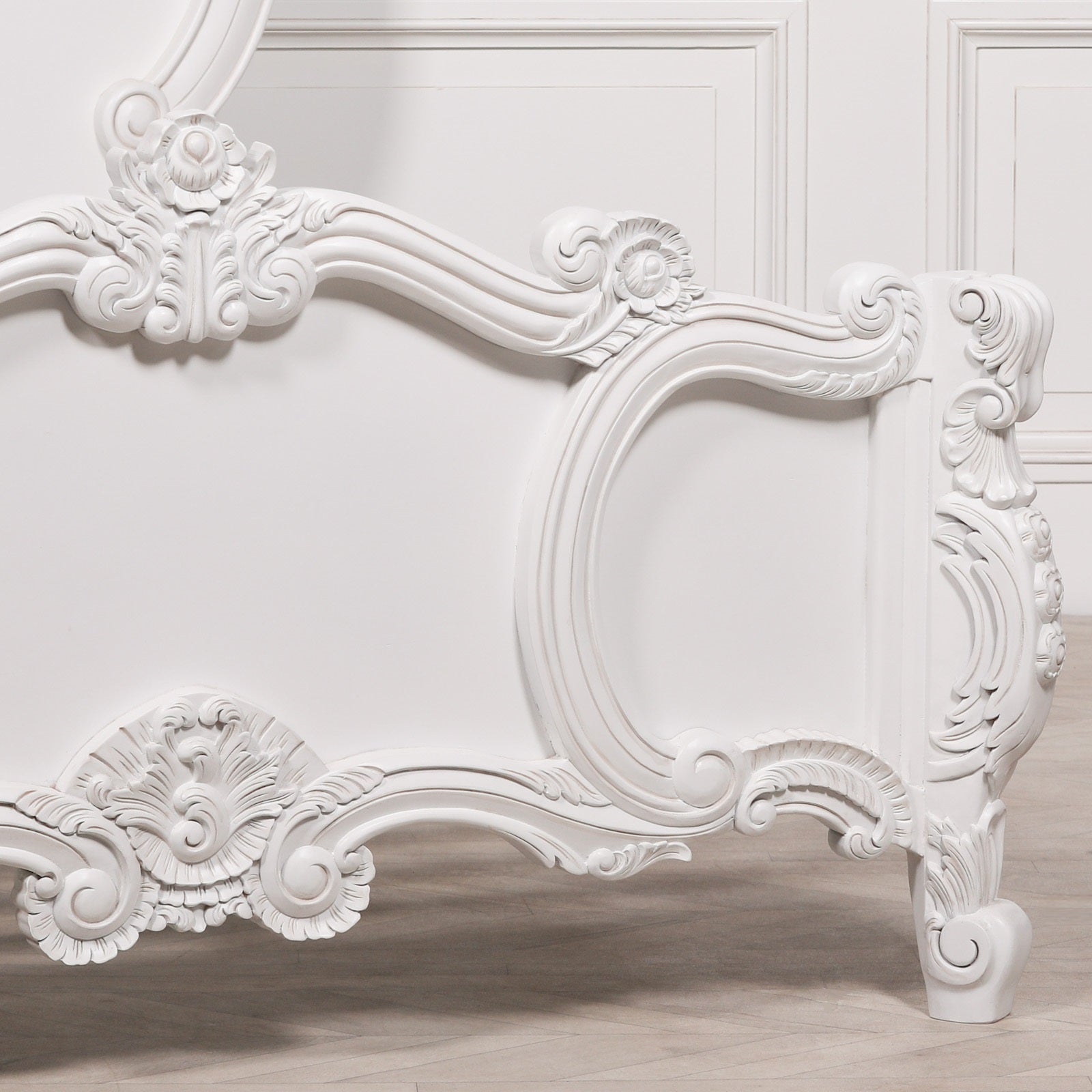 Side detail of the Rosalie French Rococo headboard with elegant hand-carved floral scrollwork, curved frame and decorative French craftsmanship in a light painted white finish.