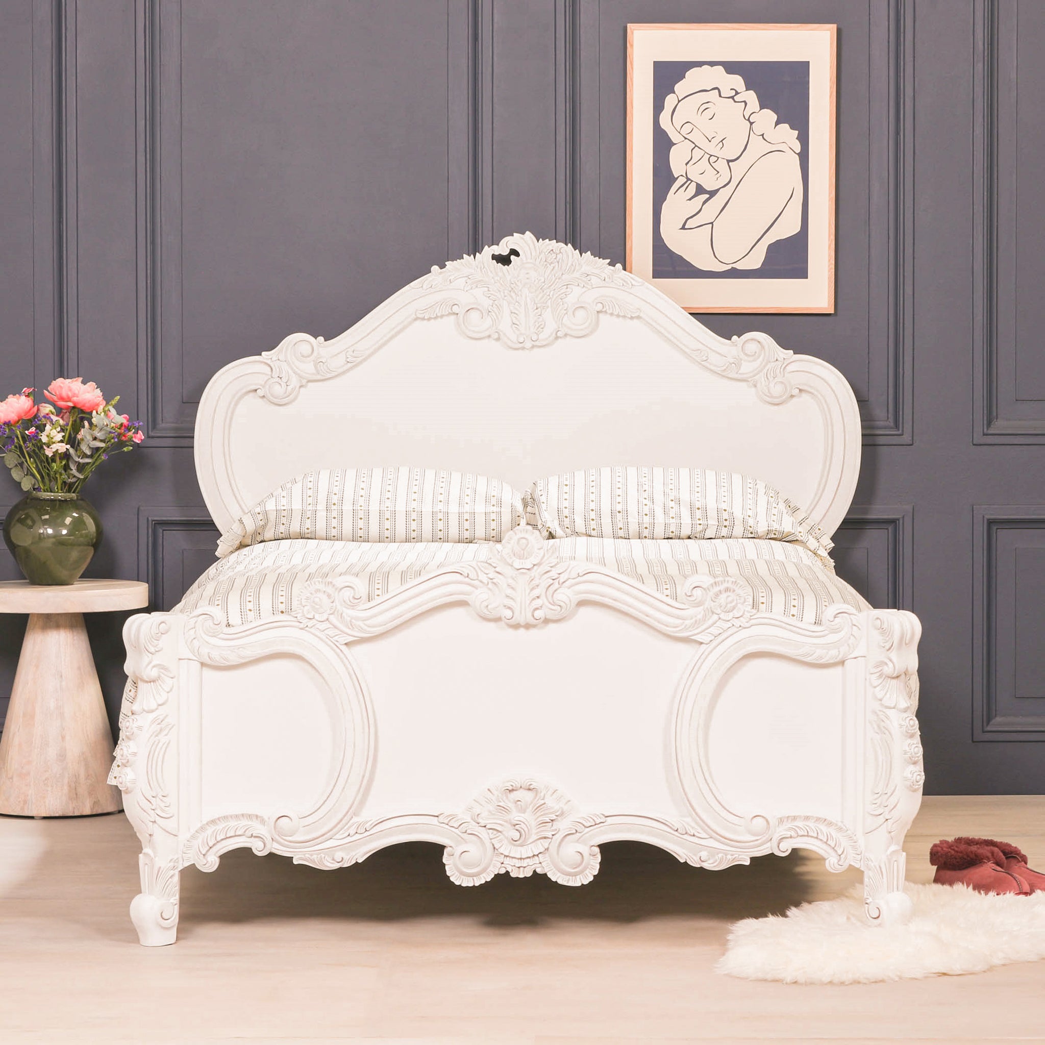 Rosalie hand-carved French Rococo king size bed frame in painted white, shown front-on in a dark panelled bedroom with ornate headboard and footboard