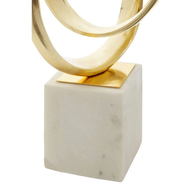Close-up of Séverin gold aluminium knot sculpture and white marble base against a plain white background.