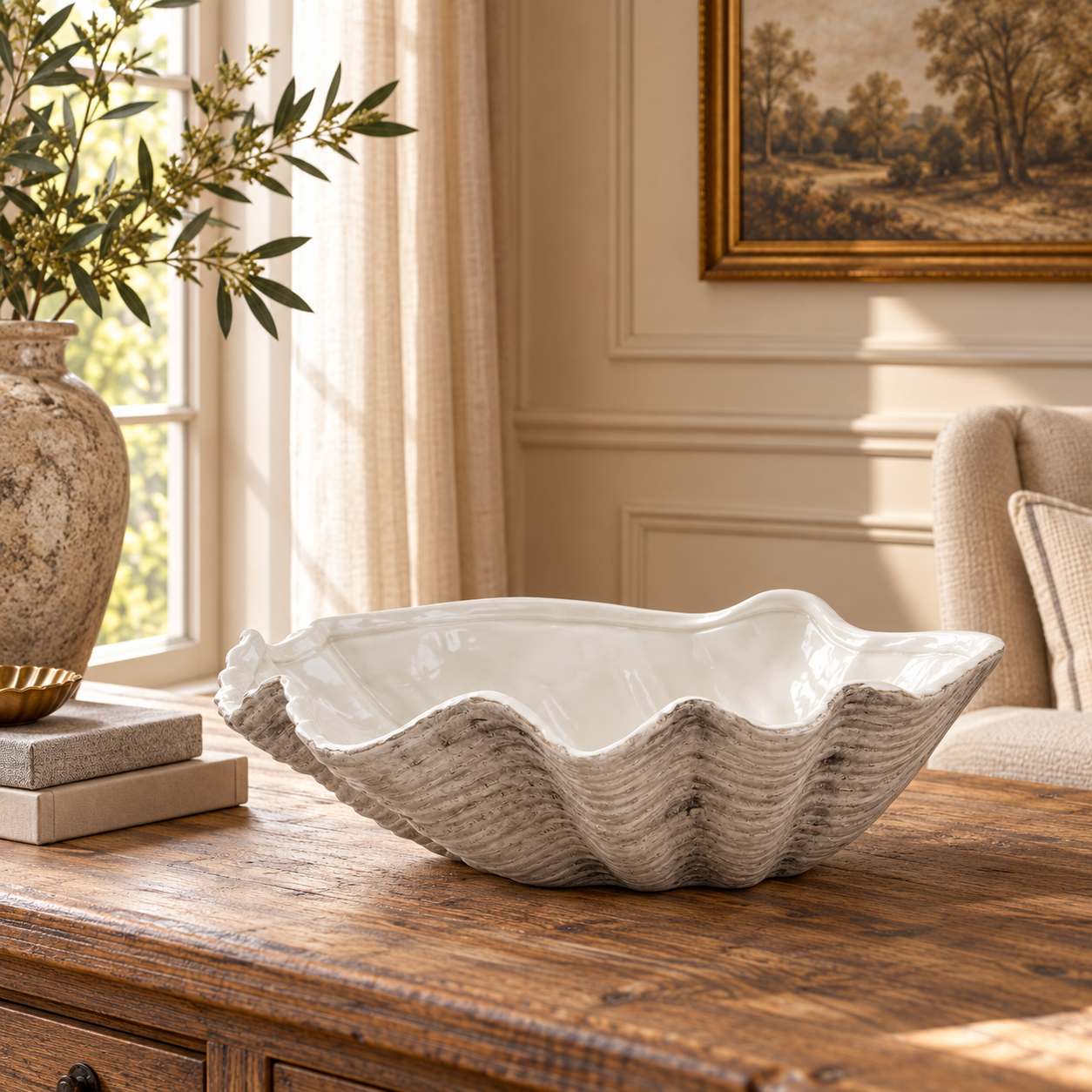 Solange 40cm white ceramic shell bowl on a rustic wood table in a sunlit neutral living room.