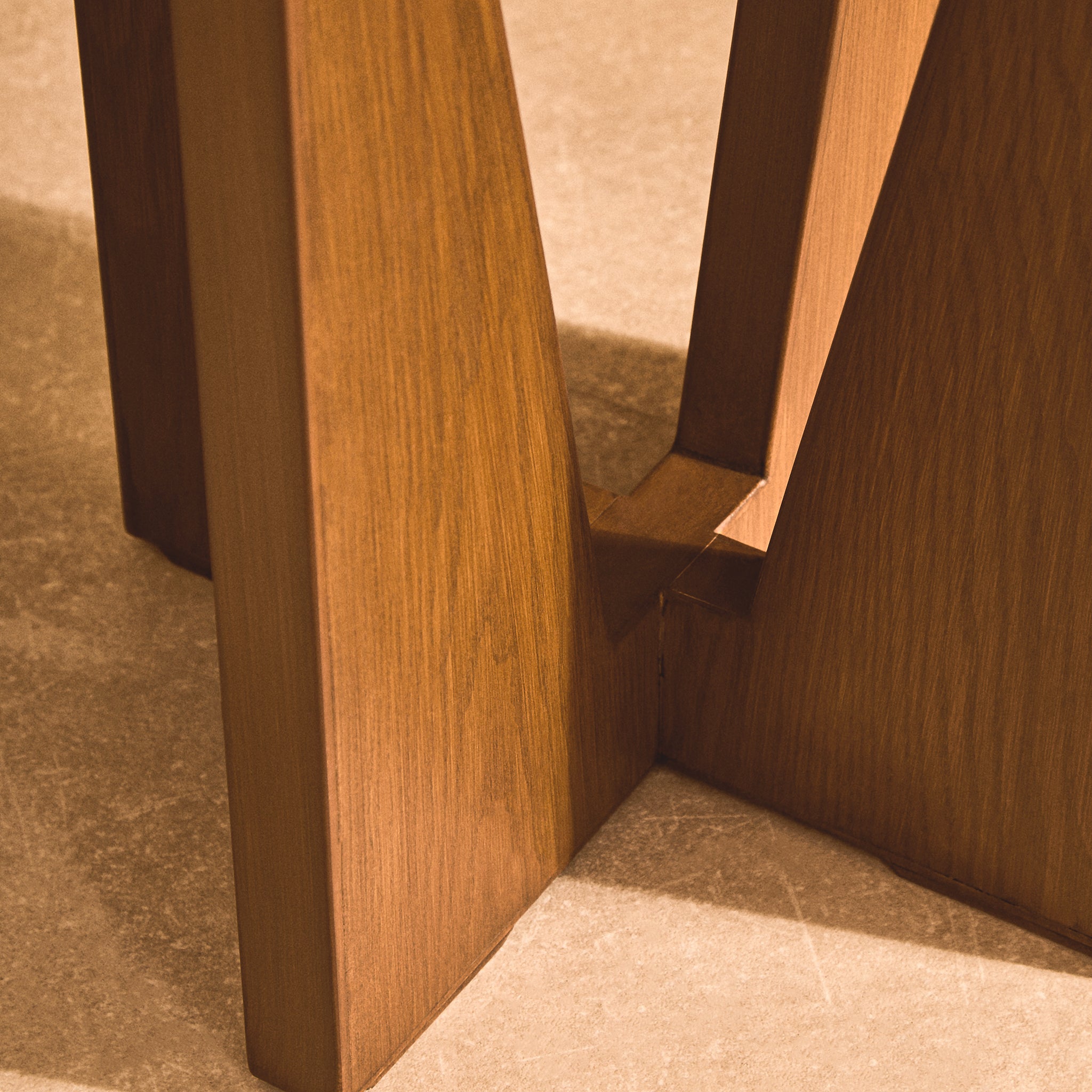 Close-up of the Soline Side Table's sculptural acacia wood frame showing the warm wood grain, angled panels and geometric construction
