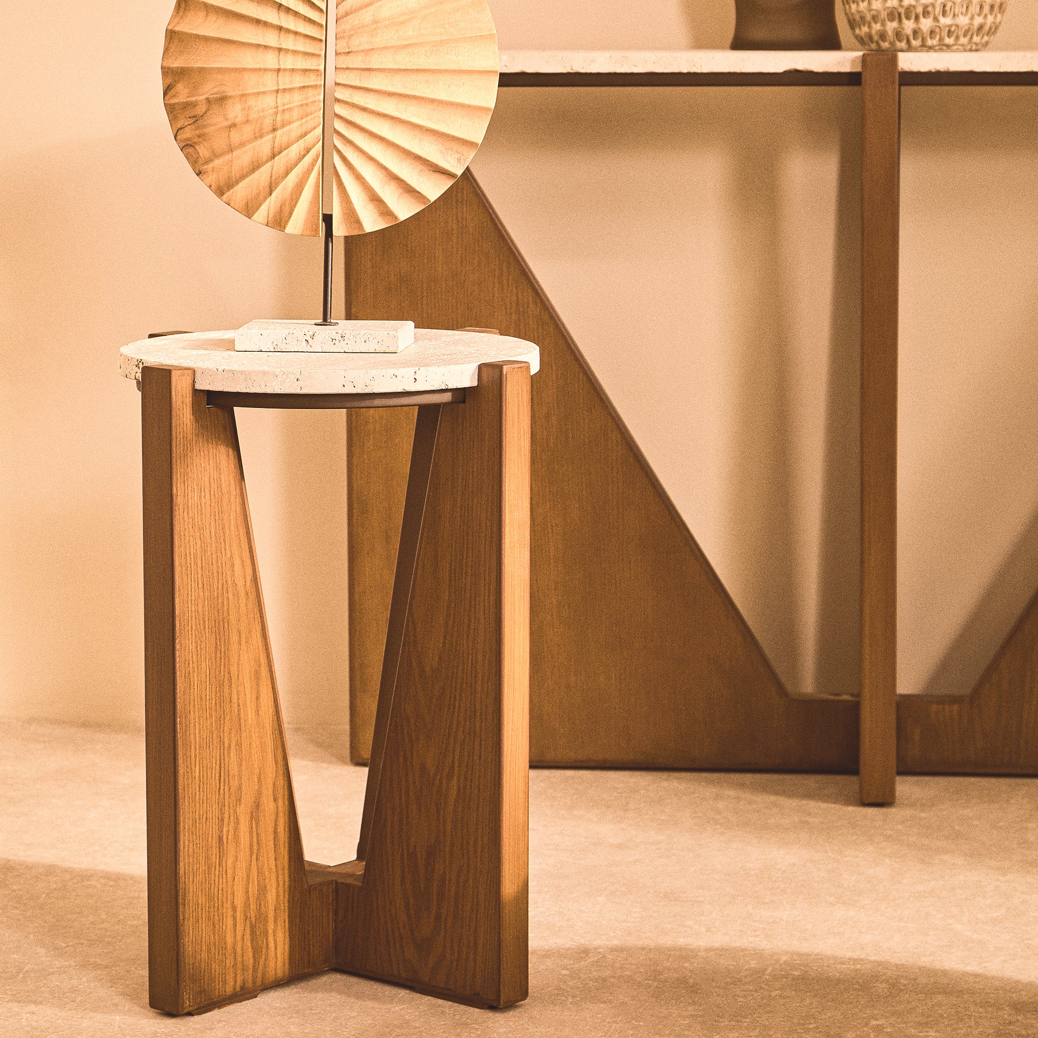 Soline Side Table with round travertine top and geometric acacia wood frame styled with a sculptural table lamp in a neutral interior