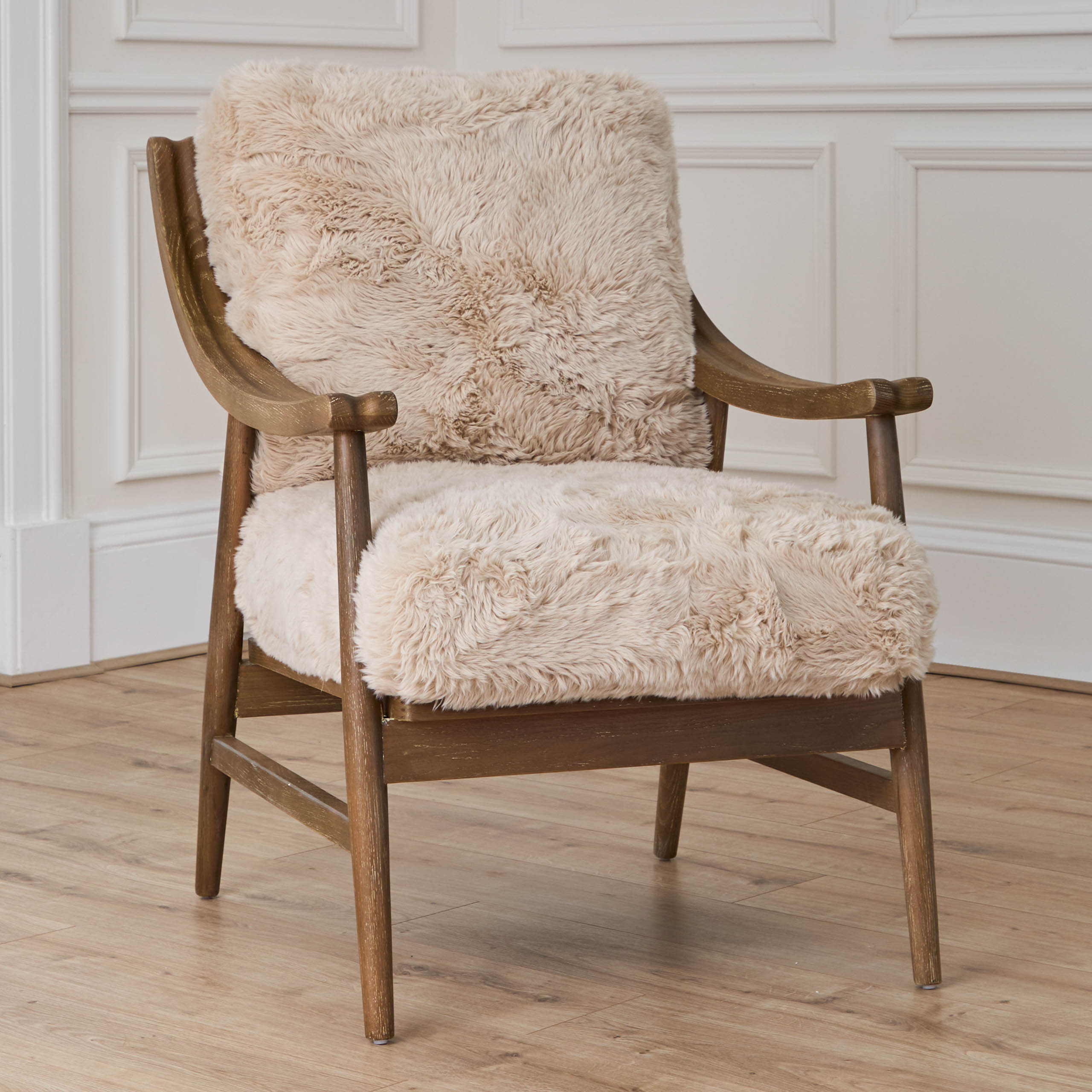 Struan natural upholstered oak accent chair, angled view against white panelled walls and light wood flooring