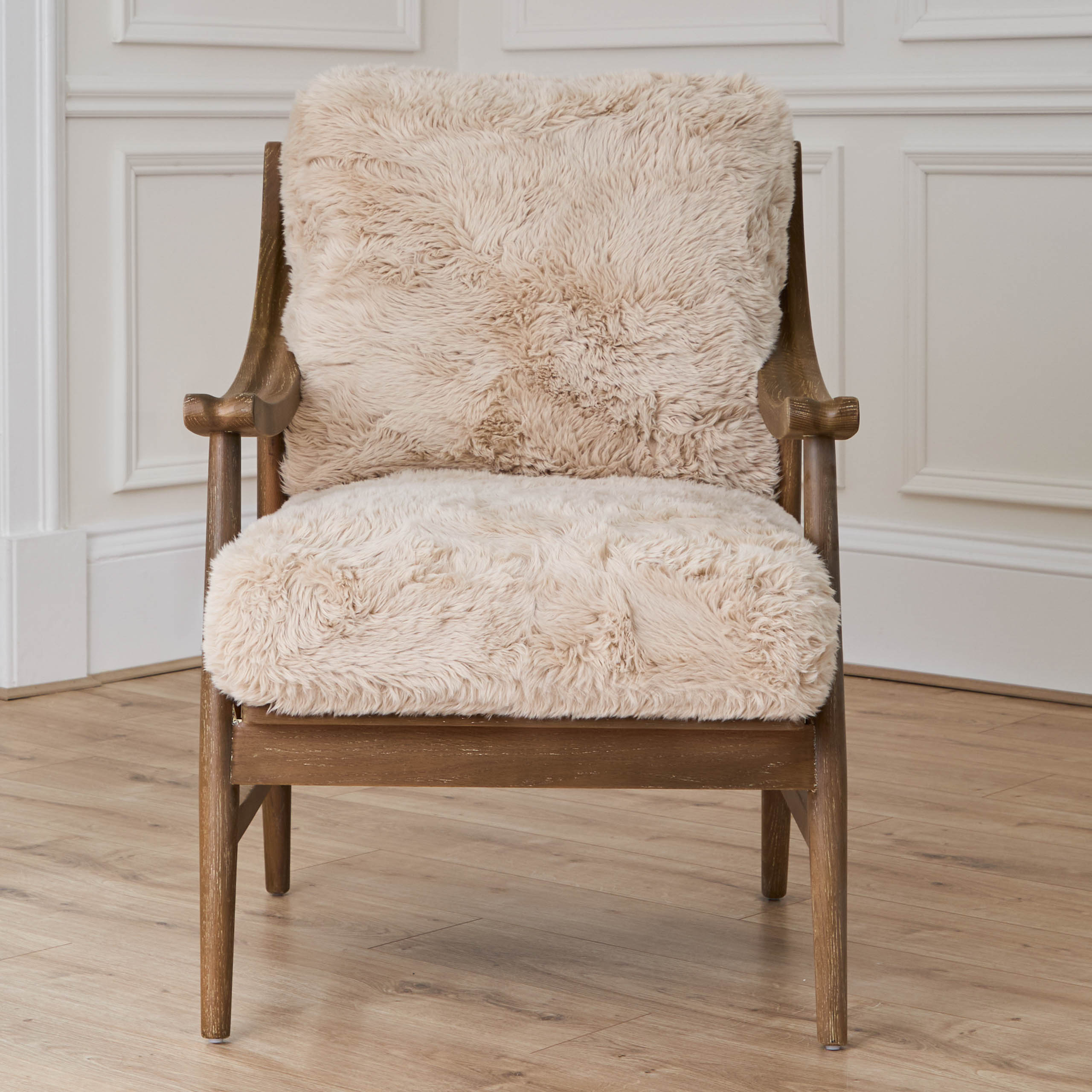 Struan solid oak upholstered accent chair, front view against white panelled walls and light wood flooring