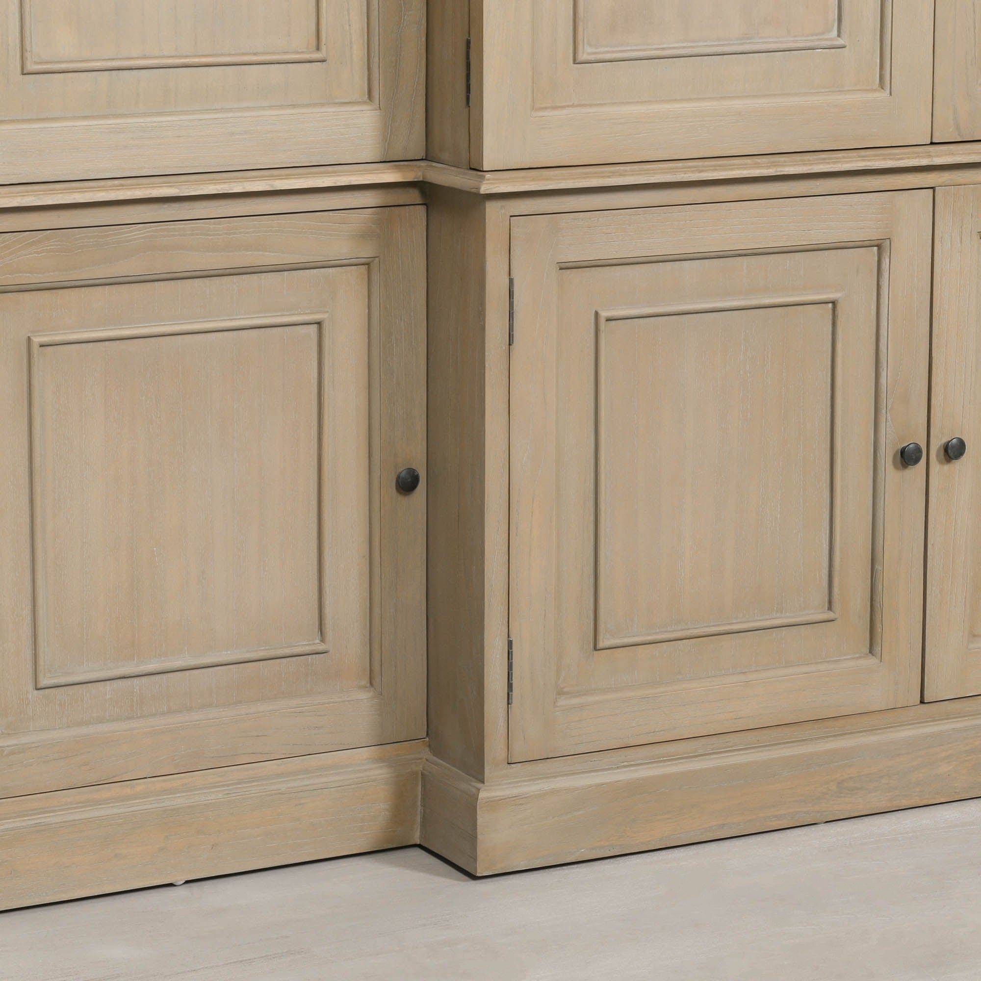 Detailed view of the lower cupboard doors on the Théodore Extra Large Triple Breakfront TV Cabinet highlighting the rustic white cedar finish, recessed panel doors, black metal knobs and concealed storage compartments.