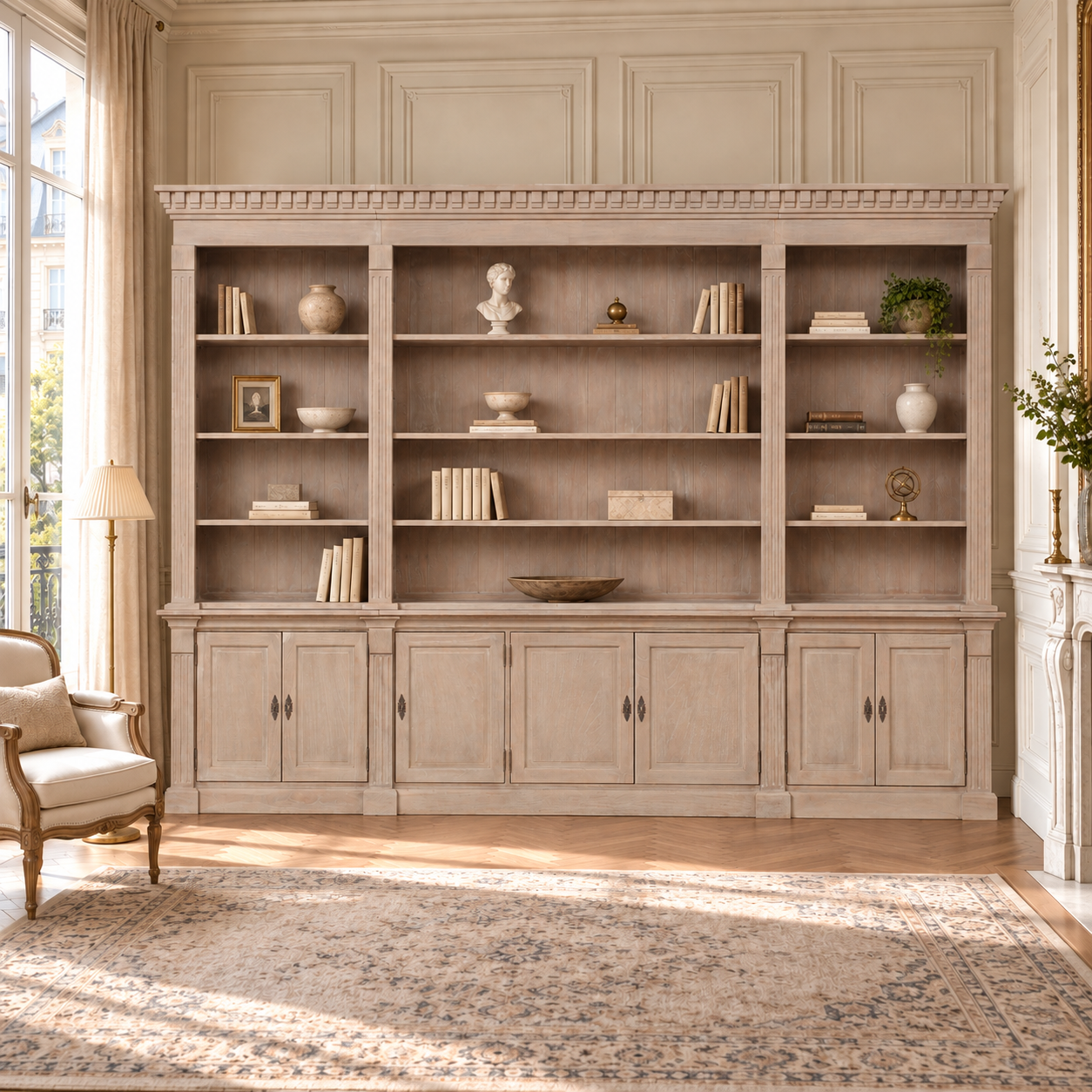 Théodore extra large triple open bookcase with storage in a sunlit French living room with fireplace and patterned rug.