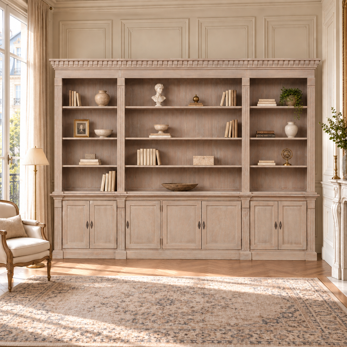 Théodore extra large triple open bookcase with storage in a sunlit French living room with fireplace and patterned rug.