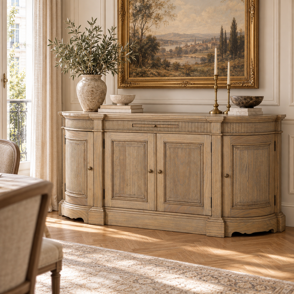 Théodore hand-carved white cedar buffet sideboard with fluted doors in a bright dining room with tall window and wood floor.