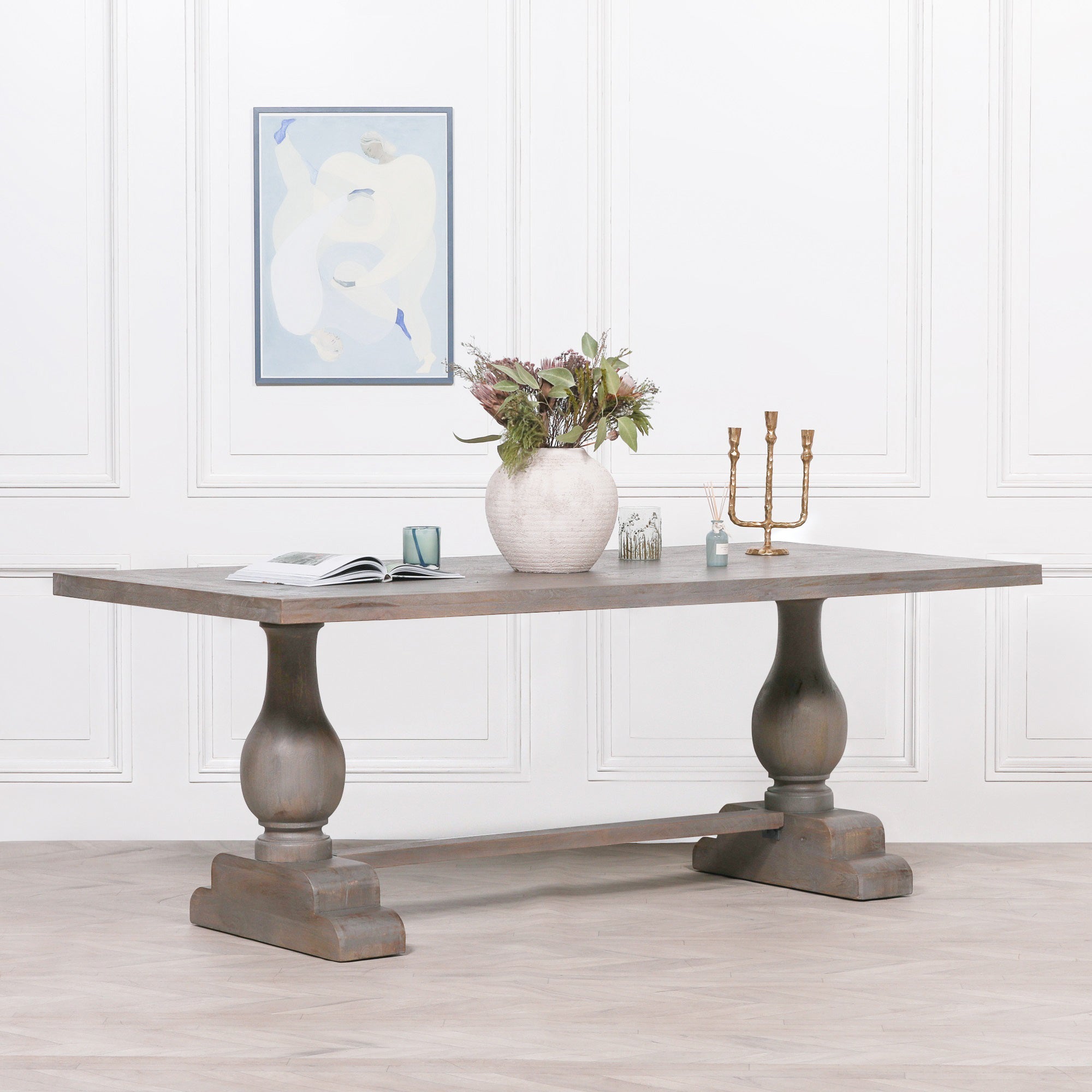 Théodore Large Rectangular Dining Table 210cm for 8–10 in Rustic Mango Wood styled with decorative accessories, showcasing the handcrafted solid mango wood tabletop, sculptural turned pedestal legs, trestle stretcher base and timeless design for elegant family dining rooms and luxury entertaining.