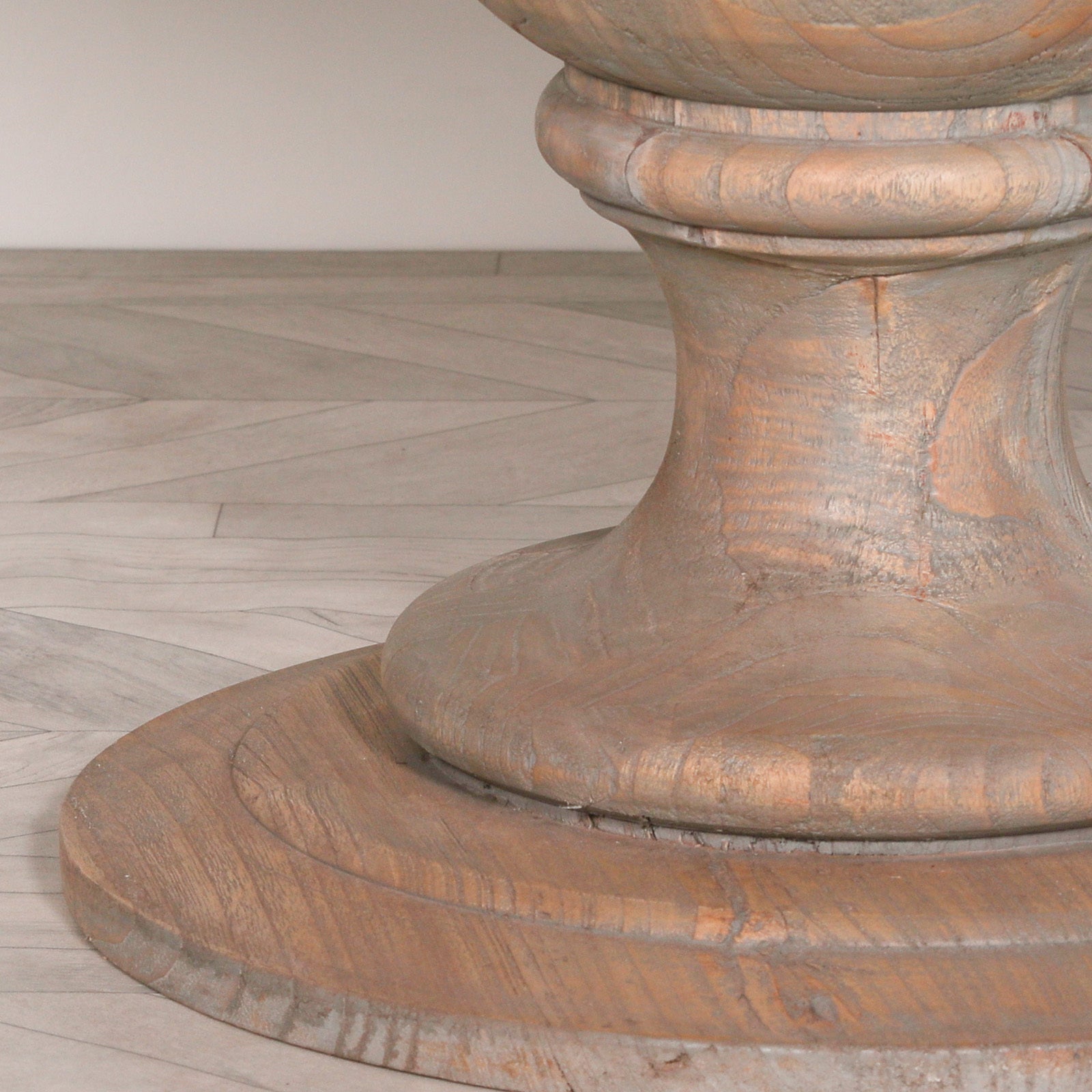 Close-up of the handcrafted pedestal base on the Théodore Large Round Dining Table, showcasing the natural mango wood grain, rustic finish, traditional turned detailing and sturdy circular base for lasting durability and stability.