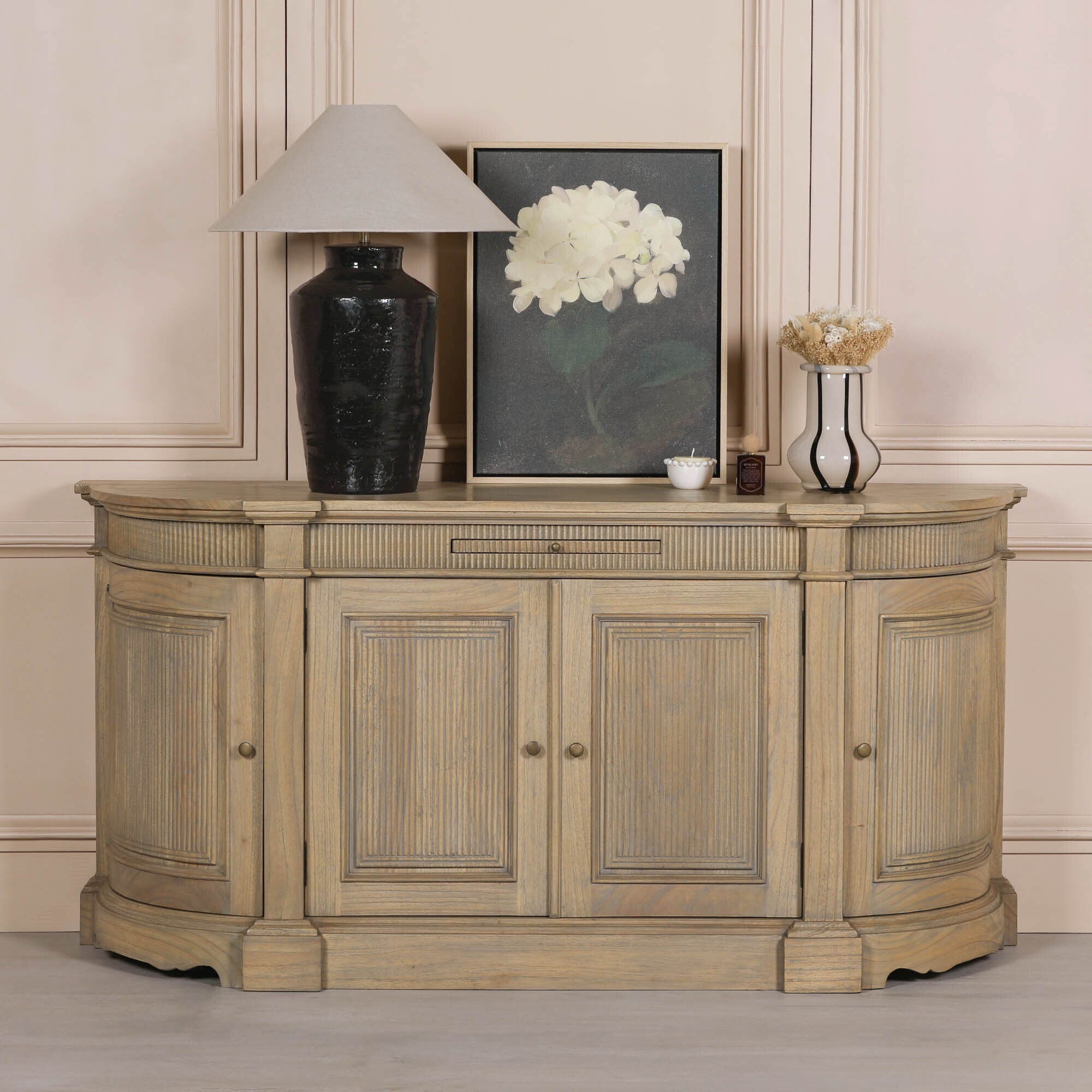 Théodore Rustic Fluted Buffet Sideboard handcrafted from white cedar wood, styled with decorative lamp, artwork and accessories, featuring fluted detailing, curved end panels and spacious four-door storage for a luxury living room or dining room.