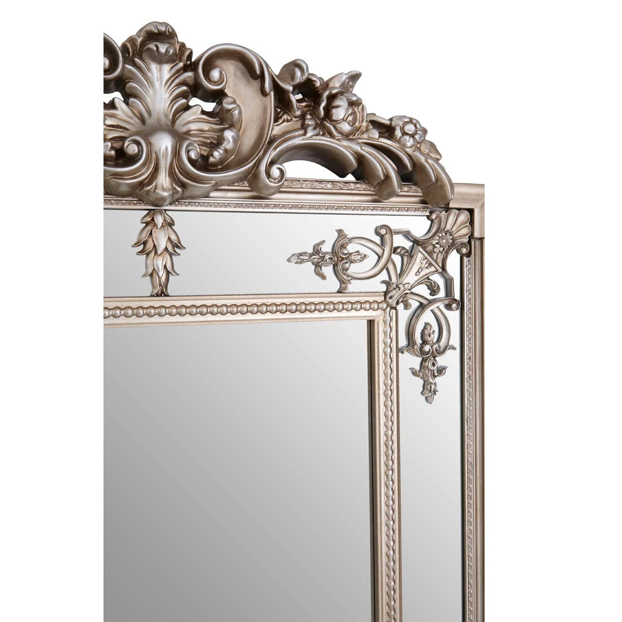 Close-up of Valère champagne gilded mirror crest with carved floral scrollwork and antique-style detailing on white.