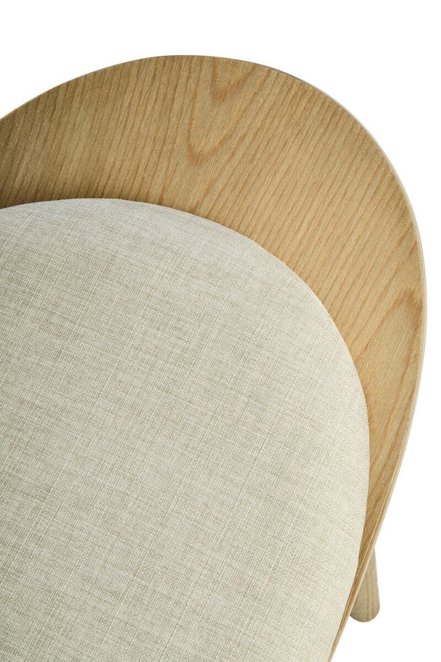 Detailed close-up of the Vincent Lounge Chair featuring the upholstered beige fabric backrest, curved washed solid elm wood shell and refined handcrafted finish.