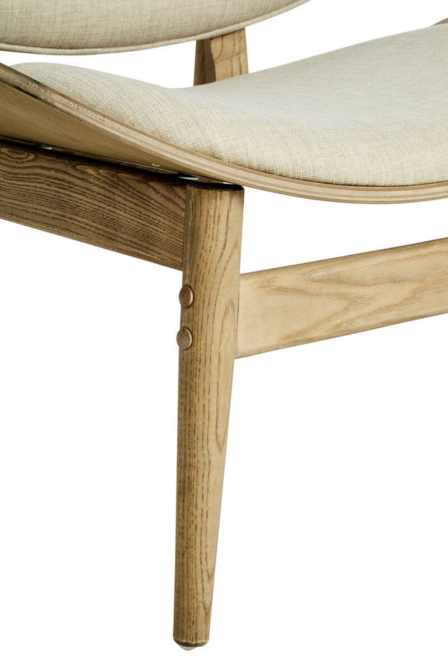 Close-up of the Vincent Lounge Chair showcasing the sculpted beige fabric seat, handcrafted washed solid elm wood frame, exposed joinery and tapered wooden legs.