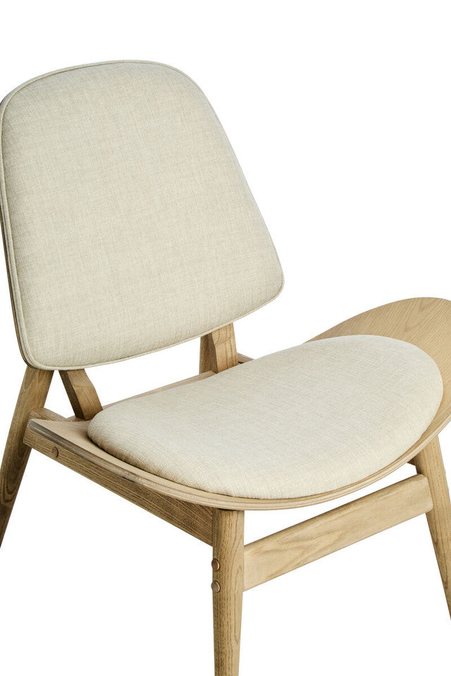Detailed view of the Vincent Lounge Chair highlighting the soft beige fabric upholstered seat and backrest, curved wooden shell and washed solid elm wood frame with premium craftsmanship.