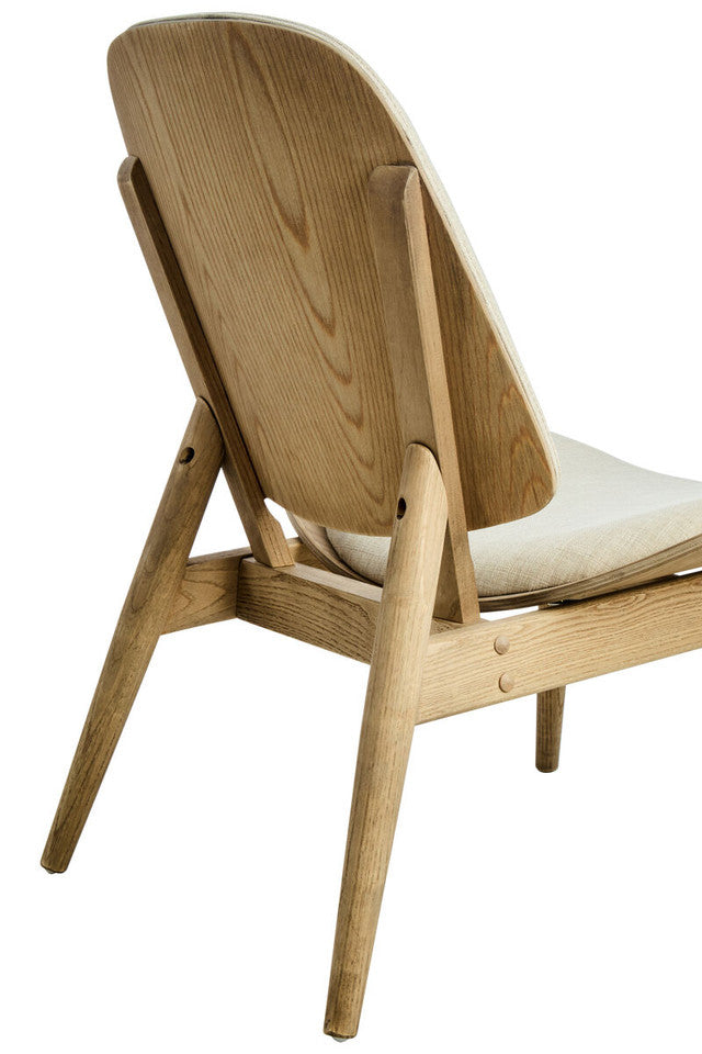 Rear angled close-up of the Vincent Lounge Chair showcasing the exposed washed solid elm wood backrest, handcrafted frame, beige fabric upholstered seat and timeless mid-century modern construction.