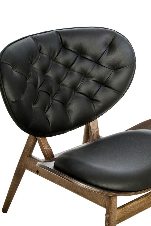 Detailed close-up of the Vincent Tufted Lounge Chair featuring the deep button tufted black leather effect backrest, supportive curved silhouette and handcrafted solid elm wood frame.
